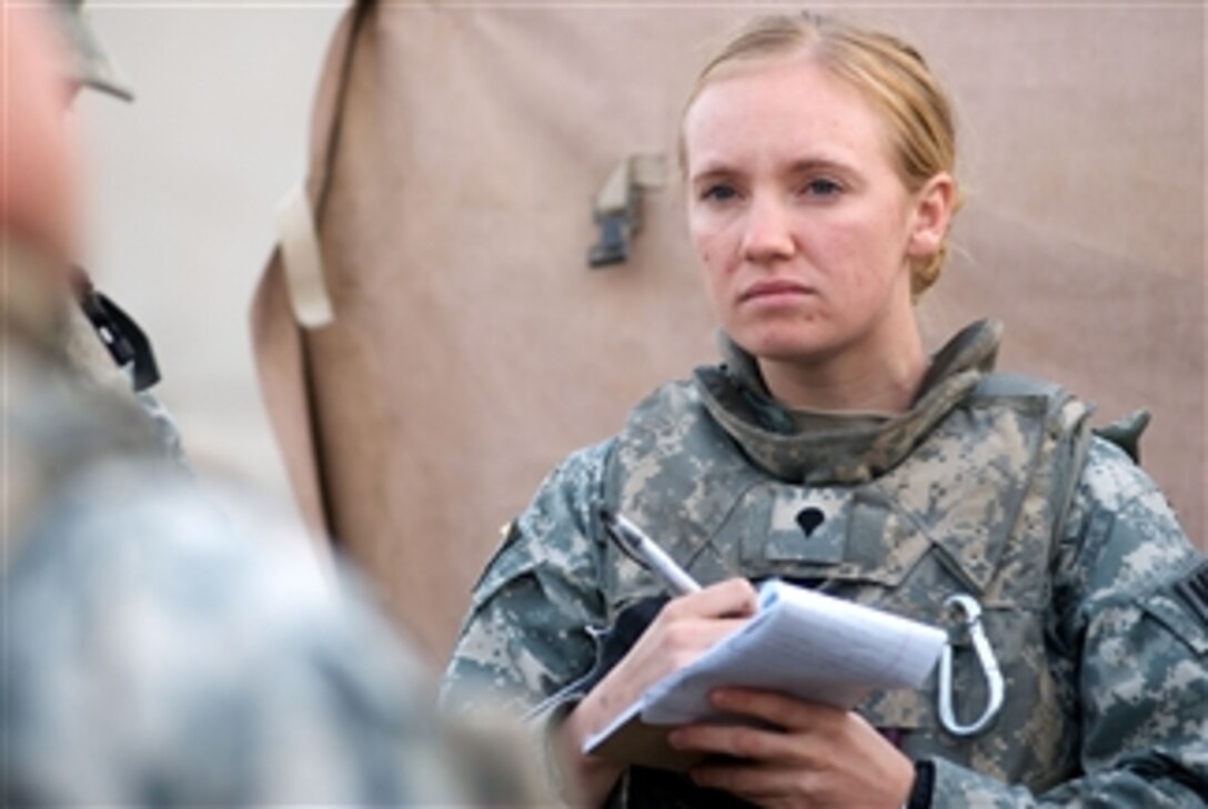 U.S. Army Spc. Melissa McIntyre with 793rd Military Police Battalion, 8th Military Police Brigade listens to a mission brief at Camp Charlie before heading out to patrol the Hayyaniyah district of Basra, Iraq, on Jan. 20, 2009.  Soldiers from the unit teamed with Iraqi police to deliver medical supplies to a local hospital.  