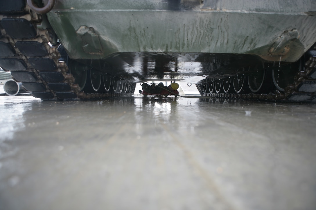 (Jan. 29, 2009) - Cpl. Mark McGuire, an M1A1 tank crewman  with Battalion Landing Team 2/6, 26th Marine Expeditionary::r::::n::Unit, cleans the bottom of a tank, January 29. The MEU-wide wash down was conducted in order to prevent any foreign contaminants from entering the United States. After each vehicle was cleaned it was put through a thorough inspection before being cleared for entry into the US. (Official USMC photo by Cpl. Jason D. Mills)(Released)