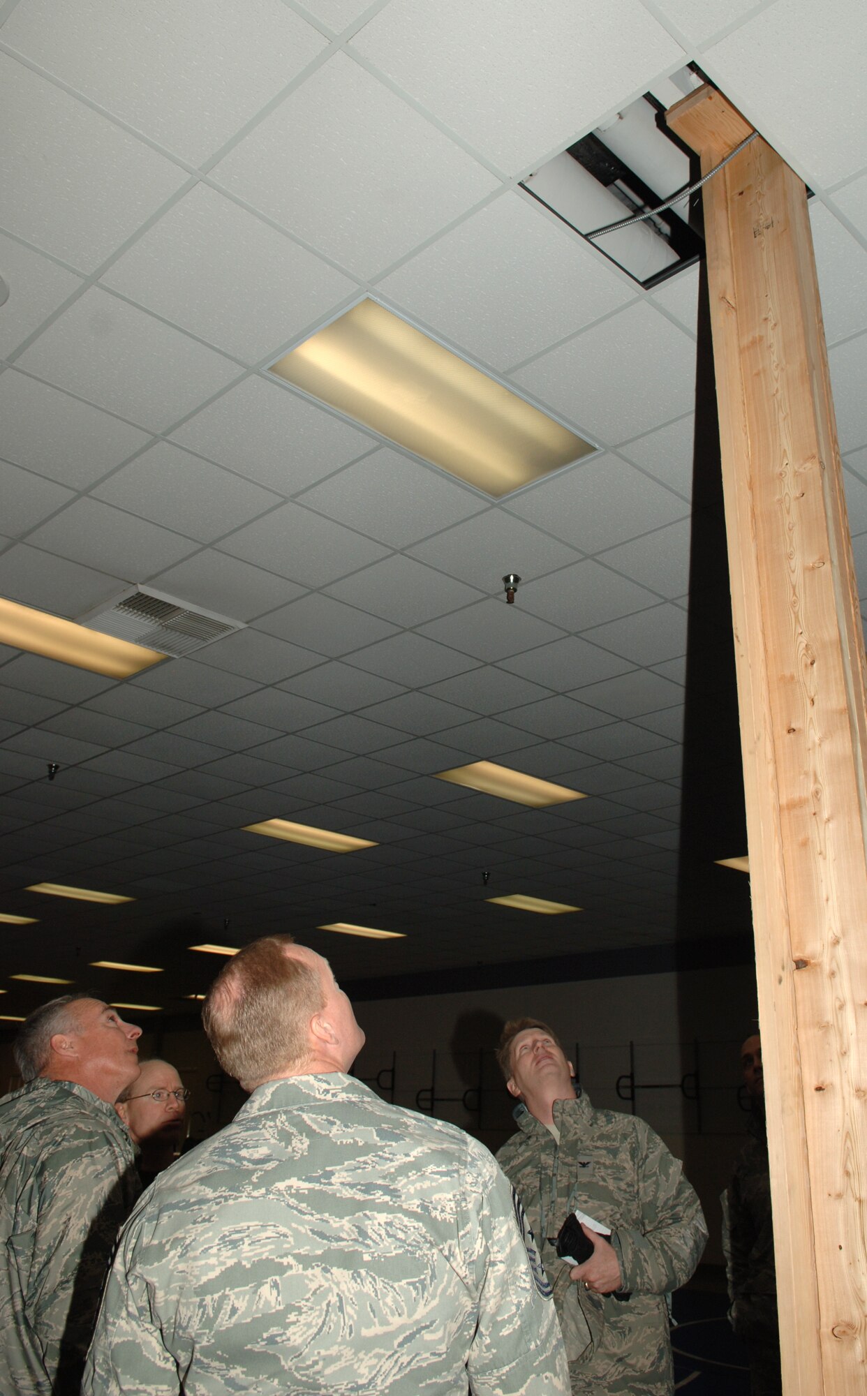 FAIRCHILD AIR FORCE BASE, Wash. – Maj. Gen. Winfield Scott, 18th Air Force commander , along with Col. Robert Thomas, 92nd Air Refueling Wing commander; Chief Master Sgt. James Cody, 18th Air Force command chief; and Mr. John Gahagan, 92nd Services Squadron fitness director; gaze upward to see damage caused to the fitness center this winter due to excessive snowfall. During his visit to Fairchild, General Scott took note of the damage caused to various buildings. (U.S. Air Force photo / Senior Airman Jocelyn A. Ford)