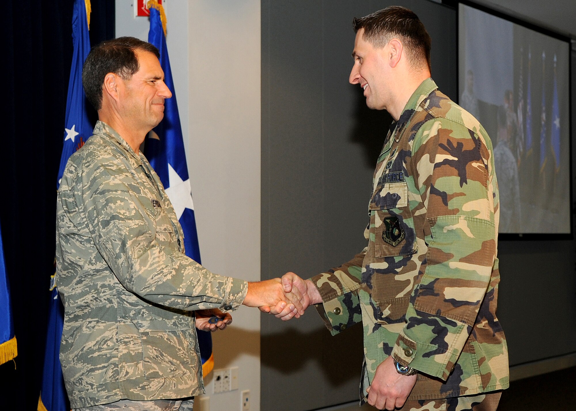 Capt. Anthony Costanza (r), Comptroller office, receives a commander’s coin from Lt. Gen. Tom Sheridan, Space and Missile Systems Center commander, during the "SMC Welcome Home Airmen Celebration" at the Gordon Conference Center, Jan. 29. Capt. Constanza was deployed during 2008. (Photo by Stephen Schester)