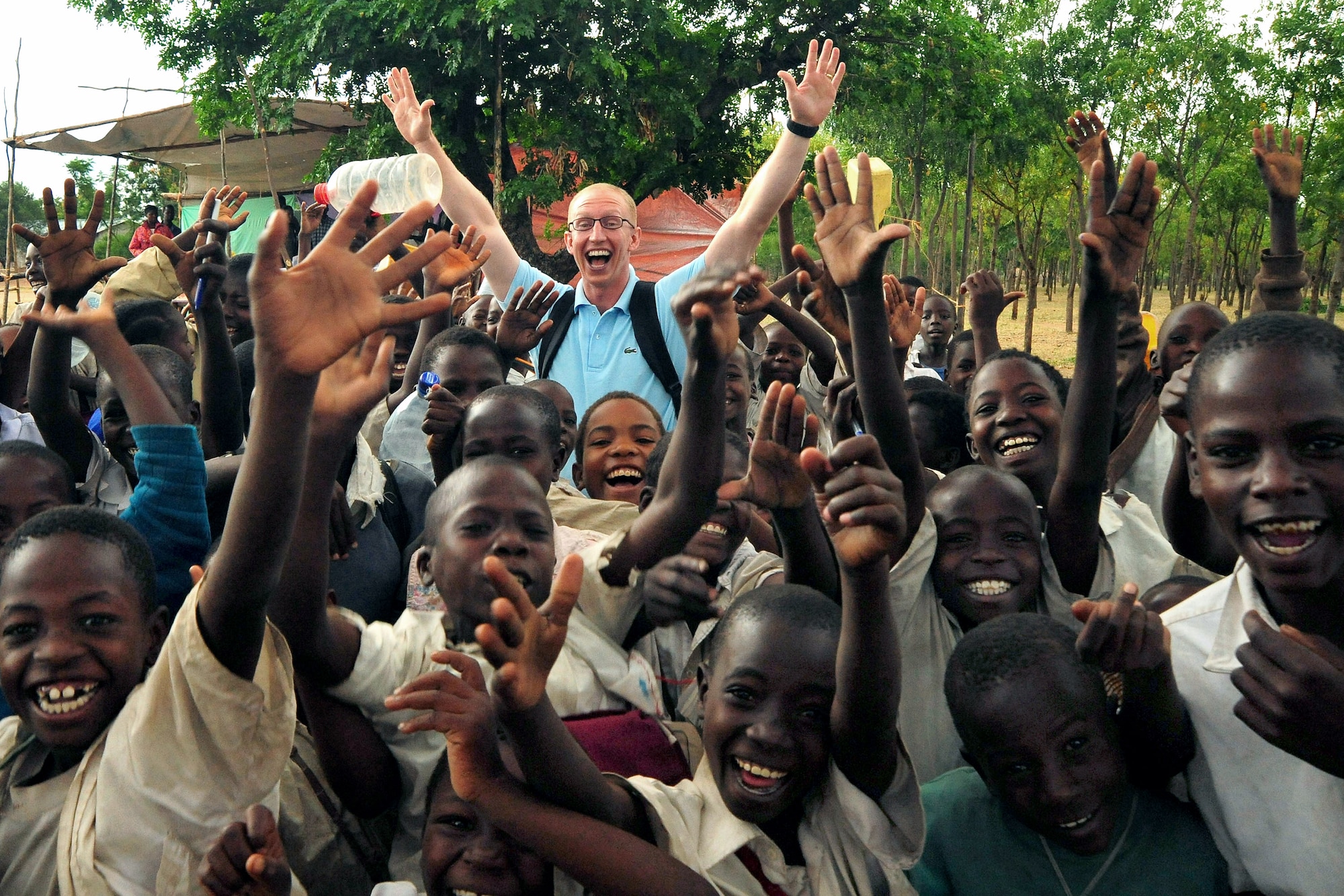 Senior Airman Daniel McKittrick celebrates with children Jan. 21 before a water project dedication in Magu, Tanzania. The project will provide clean drinking water to villagers in the region. Airman McKittrick is a public affairs broadcaster with the Combined Task Force - Horn of Africa. (U.S. Air Force photo/Staff Sgt. Joseph L. Swafford Jr.)