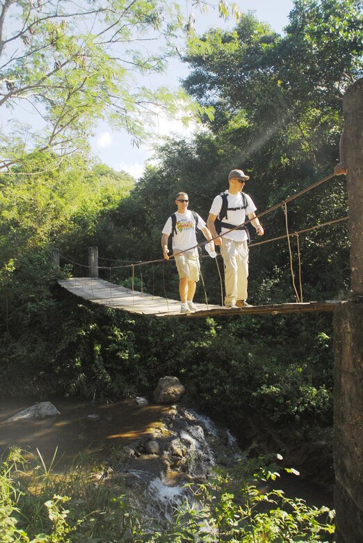 SOTO CANO AIR BASE, Honduras - Senior Airman Mike Kearns (left) and Michael Connelly, Joint Task Force-Bravo, check out the view from a locally built bridge during a chapel hike to El Sitio, Honduras, Jan. 24.   More than 80 men and women from JTF-B here climbed into the hills outside Comayagua to bring food and toys to the people who live there. (US Air Force photo/Tech. Sgt. Rebecca Danét)