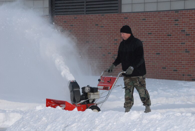 SCOTT AIR FORCE BASE, Ill. - Master Sgt. Terry Szwet, the aircraft structural maintenance shop supervisor with the 126th Maintenance Squadron, works to clear a path through more than five inches of snow that piled up during the two-day winter storm that caused Scott AFB to be minimally manned.  The 126th MXS is assigned to the 126th Air Reufeling Wing, Scott AFB, Ill., and is part of the Illinois Air National Guard. (U.S Air Force photo by Staff. Sgt. Jessica Briney)