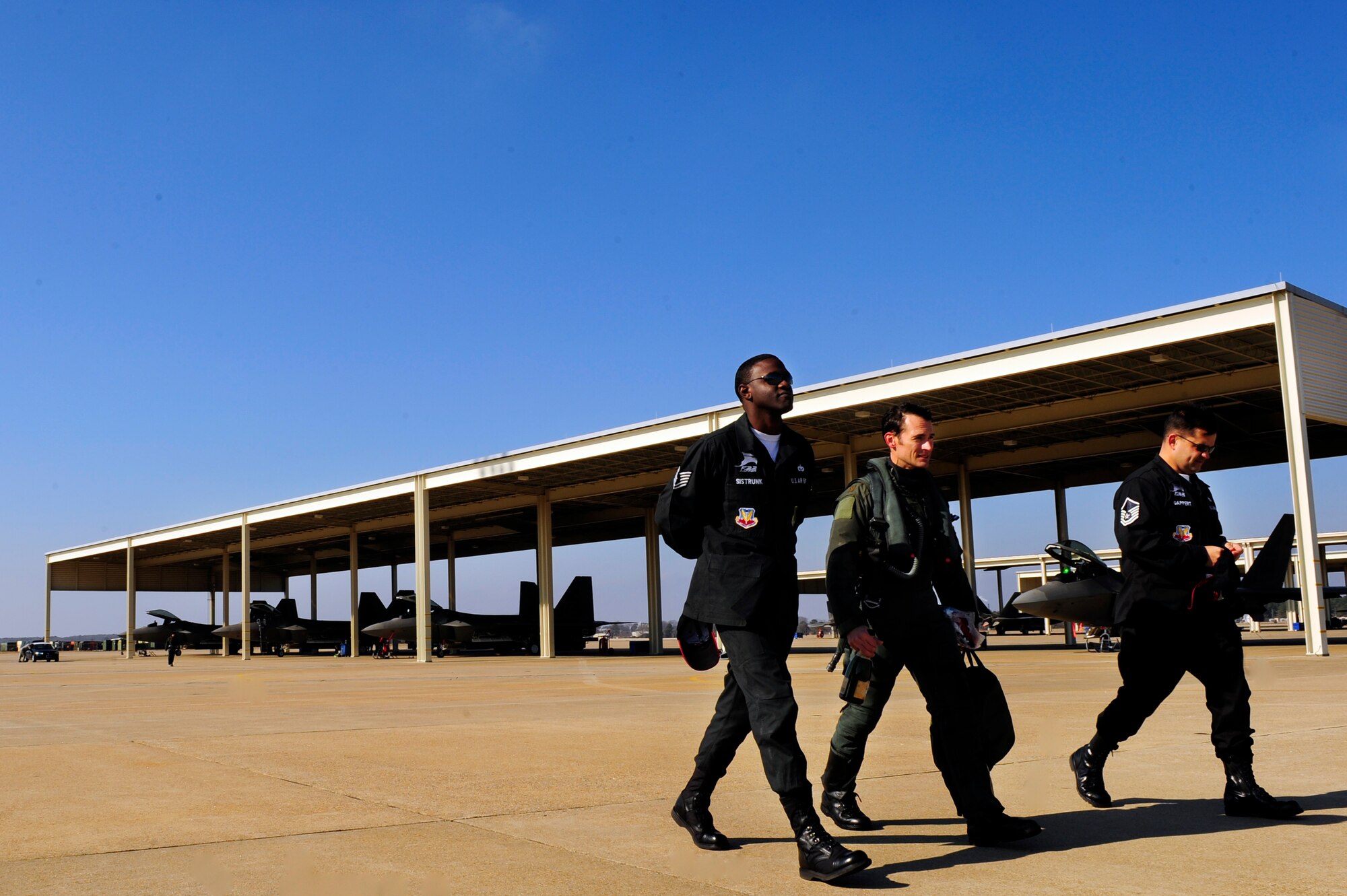 LANGLEY AIR FORCE BASE, Va. -- Maj. Paul "Max" Moga, F-22A Raptor Demonstration Team pilot, walks with Tech. Sgt. Gabriel Sistrunk and Master Sgt. Greg Gappert, demo team crew chiefs, after his final flight as demo team pilot Jan. 29. Hampton Roads Air Force Week begins April 18, and the 2009 F-22A Demonstration Team pilot is Maj. Dave "Zeke" Skalicky, who will perform here for AirPower over Hampton Roads April 24 to 26. (U.S. Air Force photo/Senior Airman Vernon Young)