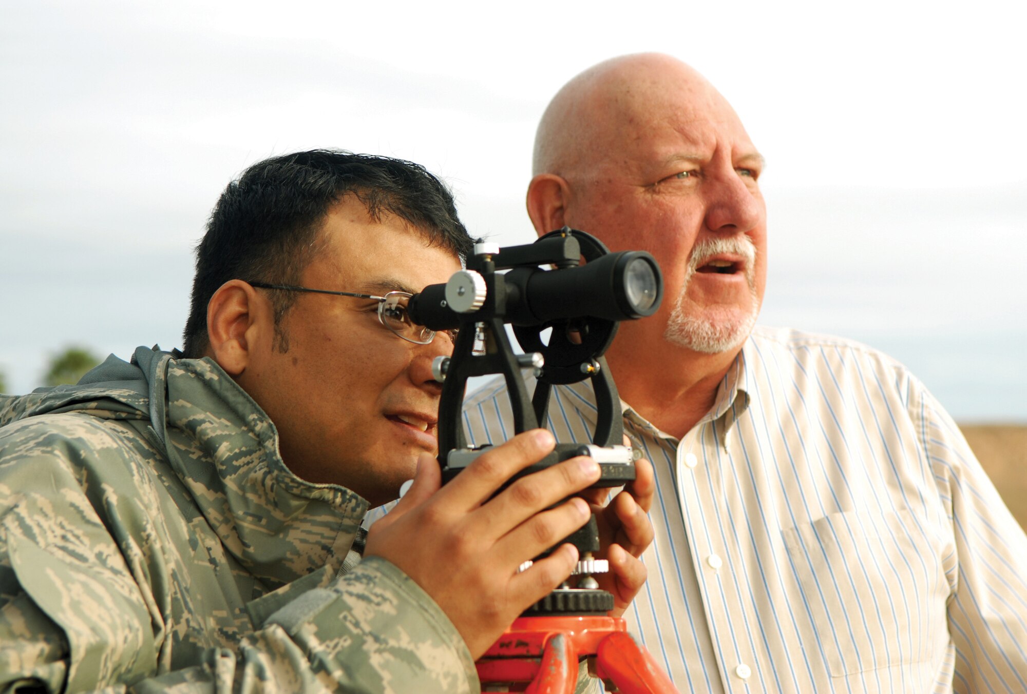 Jeff Strand, right, instructor contractor from the Computer Science Corporation, helps Tech. Sgt. Edward Conde, 606th Air Control Squadron ground radar technician from Spangdahlem Air Base, Germany, with the transit at the 607th ACS TPS-75 radar training site Jan. 22. The transit is a device used to see where the TPS-75 radar will start and stop transmitting — also known as “blanking.”  (U.S. Air Force photo/Airman 1st Class Ronifel Yasay)