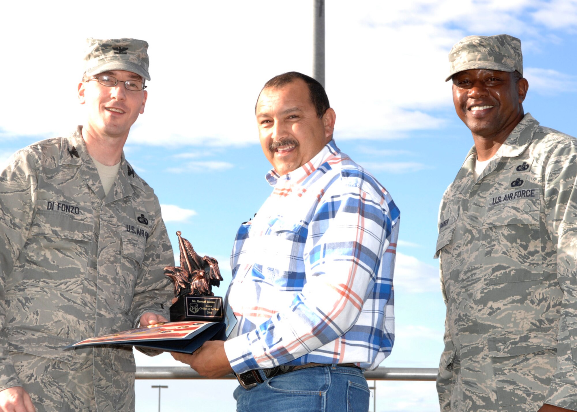 Mr. Samuel Lueras, 49th Civil Engineer Squadron, wins in the civilian category three at the 49th Mission Support Group's annual awards formation ceremony, Jan. 23 at Holloman Air Force Base, N.M. The award is presented by Col. Stephen Difonzo, 49th MSG commander and Chief Master Sgt. Jerome Baker, 49th MSG superintendent. (U.S. Air Force photo/Airman 1st Class Rachel A. Kocin)