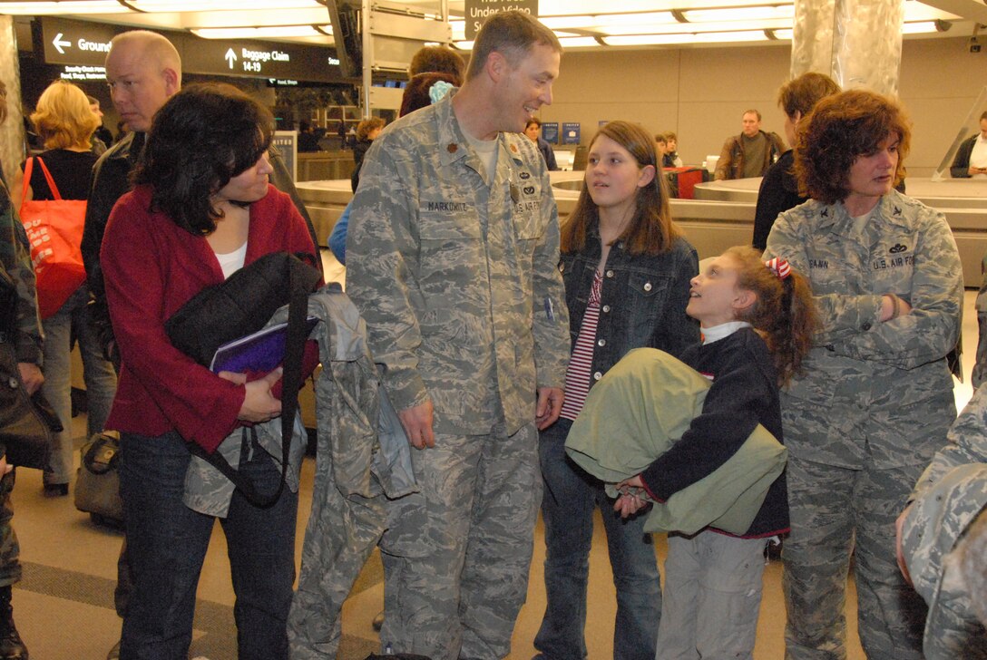 Major Tim Markowitz and his wife, Meridth, talk to their daughters, Olivia and Grace, upon return from a six-month deployment to Afghanistan.  Maj. Markowitz worked on a six-man Facilities Engineer Team at a remote Forward Operating Base with the Army.