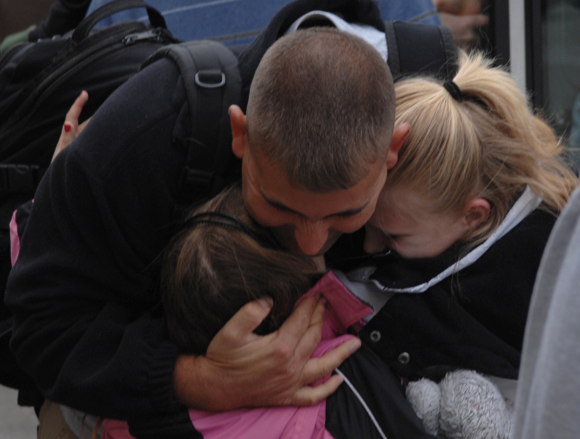 WHITEMAN AIR FORCE BASE, Mo. – A member of Team Whiteman returns from deployment March 3 and embraces his children after stepping off a bus. Hundreds of Airmen from the 509th deployed throughout the year and returned home to families and loved ones. (U.S. Air Force photo/Senior Airman Jessica Snow)