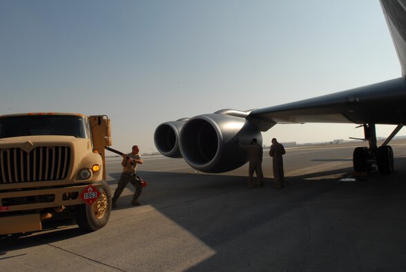 SOUTHWEST ASIA -- Senior Airman Zachery Belcher, 380th Logistics Readiness Squadron fuels distribution operator brings out a fuel hose for refueling of a KC-135 Stratotanker as crew members perform pre-flight inspections, Jan 27. Airman Belcher was one piece of the bases effort to recover and turn several KC-135's after they were diverted from their original destination. Airman Belcher is deployed from Eglin AFB, Fla. and hails from Linclon, Ala. (U.S. Air Force photo by Captain Jennifer Pearson) (Released)
