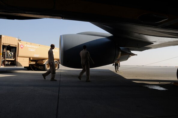 SOUTHWEST ASIA -- Senior Airman Zachery Belcher, 380th Logistics Readiness Squadron fuels distribution operator connects a grounding cable as crew members perform pre-flight inspections on a KC-135 Statotanker, Jan 27. Airman Belcher was one piece of the bases effort to recover and turn several KC-135's after they were diverted from their original destination. Airman Belcher is deployed from Eglin AFB, Fla. and hails from Lincoln, Ala. (U.S. Air Force photo by Senior Airman Brian J. Ellis)