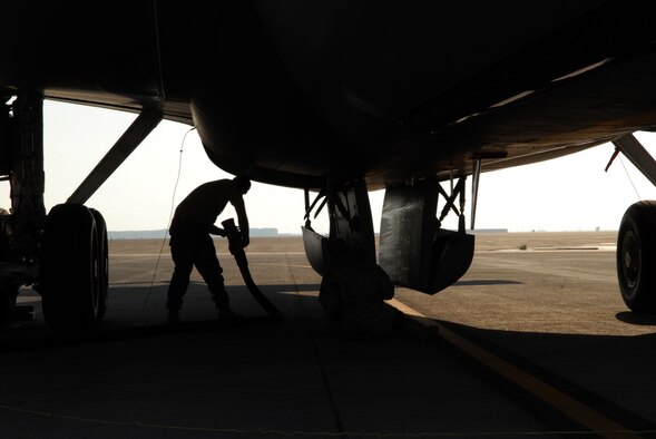 SOUTHWEST ASIA -- Senior Airman Zachery Belcher, 380th Logistics Readiness Squadron fuels distribution operator brings out a fuel hose for refueling of a KC-135 Stratotanker, Jan 27. Airman Belcher was one piece of the bases effort to recover and turn several KC-135's after they were diverted from their original destination. Airman Belcher is deployed from Eglin AFB, Fla. and hails from Lincoln, Ala. (U.S. Air Force photo by Captain Jennifer Pearson)