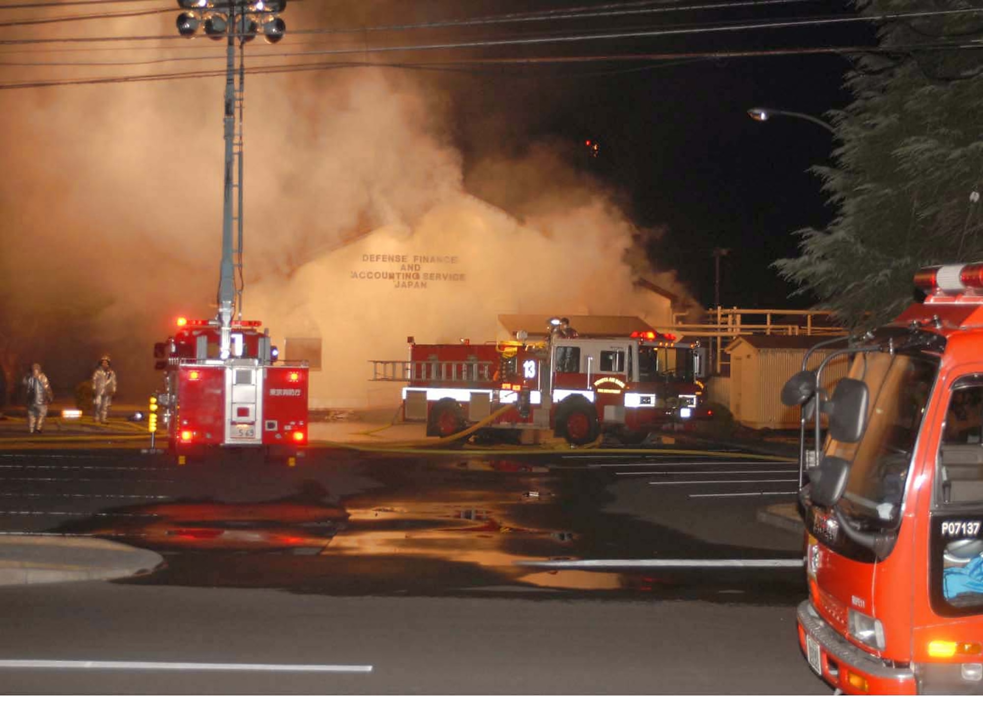 Firefighters from the 374th Civil Engineer Squadron and the Tokyo Metropolitan Fire Department work together to fight a fire at the Defense Finance and Accounting Service Japan building that caught fire at about 6:30 p.m. Jan. 20 at Yokota Air Base, Japan. (U.S. Air Force photo/Airman Sean Martin) 
