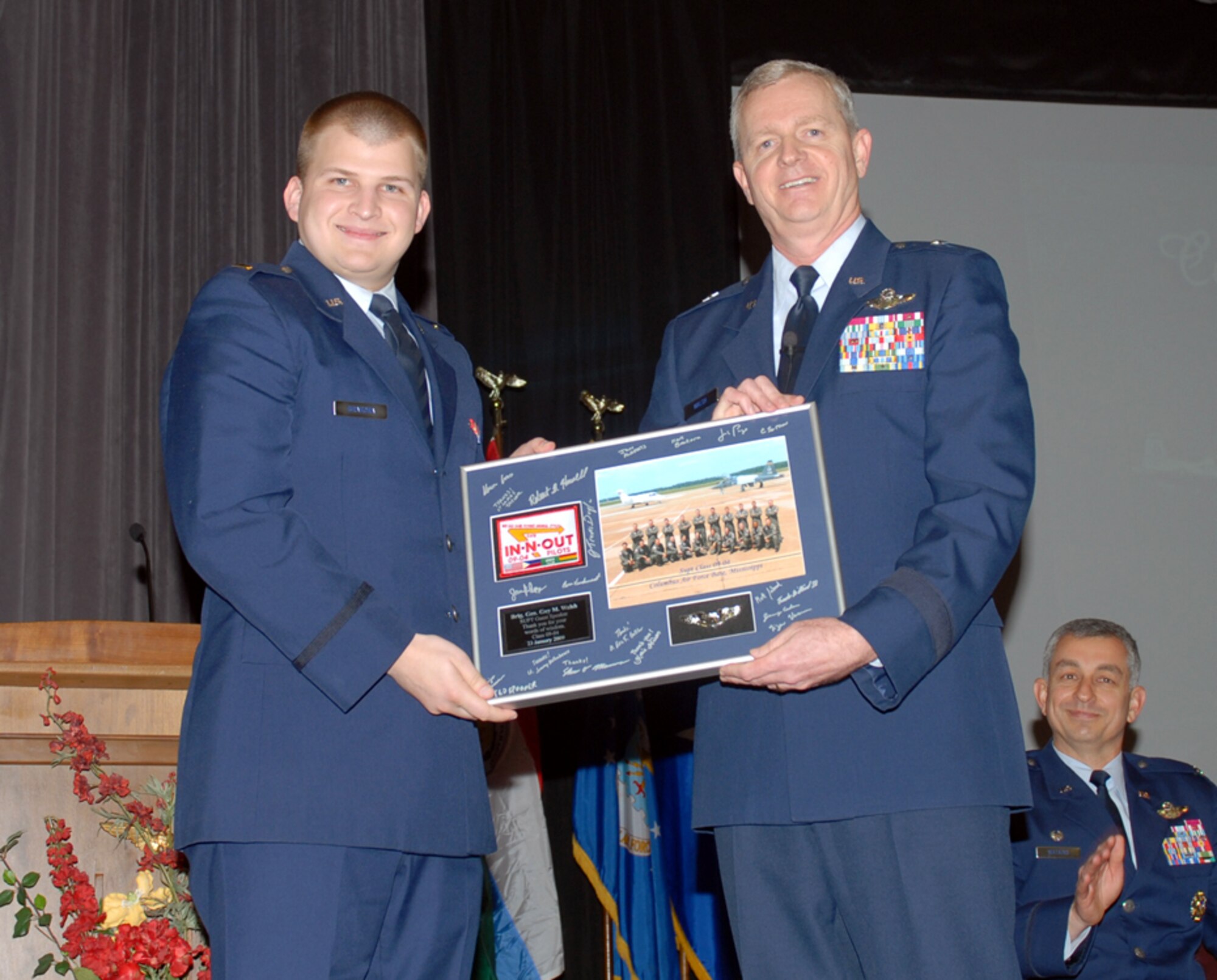 Second Lt. Kenneth Brakora, class leader of Undergraduate Pilot Training Class 09-04, presents Brig. Gen. Guy Walsh, Commander, 175th Wing, Maryland Air National Guard, Baltimore, Md., a class photo as a token of appreciation for speaking at SUPT class 09-04’s graduation at Kaye Auditorium Friday. (U.S. Air Force photo by Melissa Duncan)