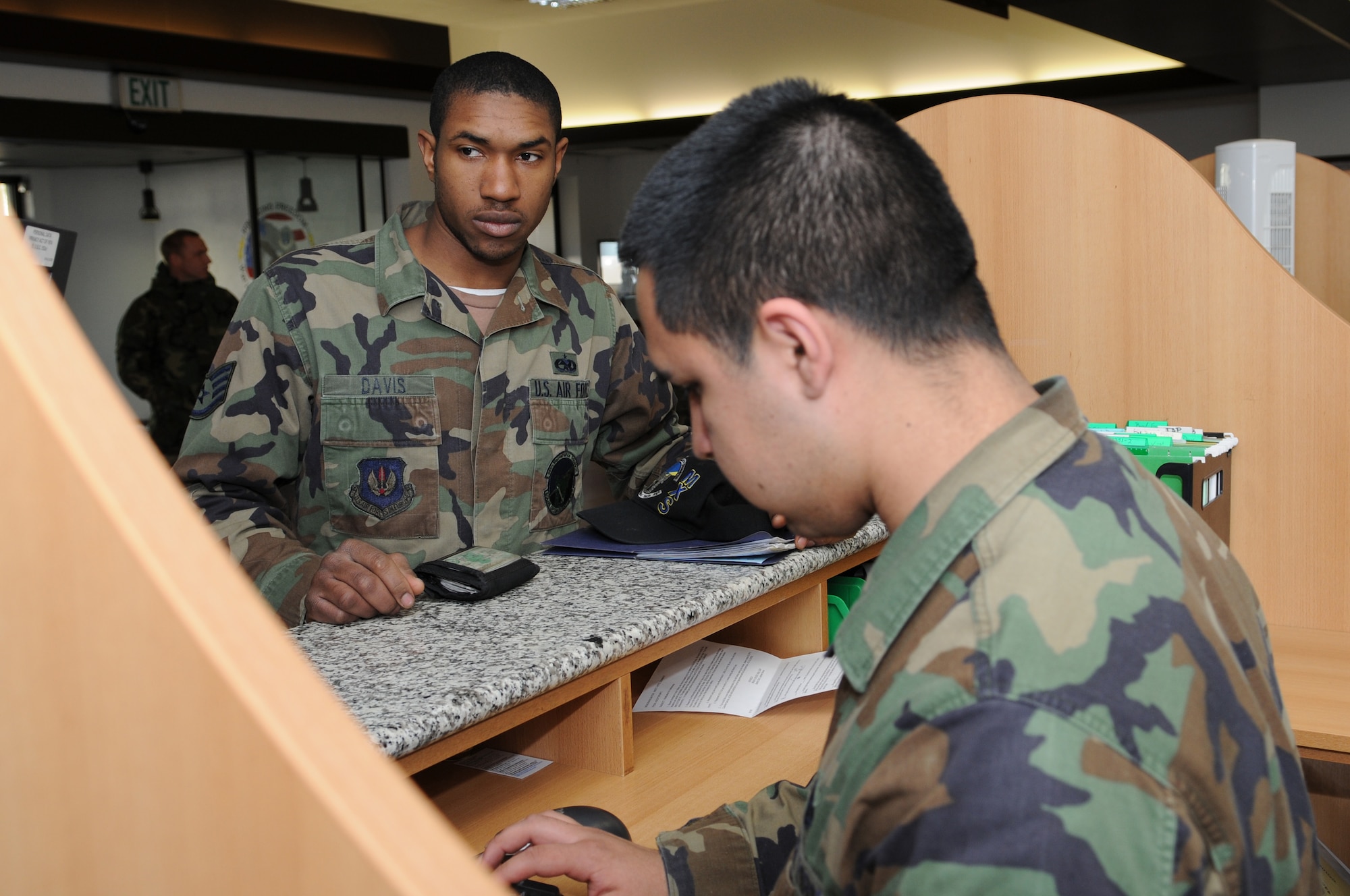 Airman 1st Class Andrew Pena (front), 435th Comptroller Squadron customer service technician, helps Staff Sgt. Harold Davis, 86th Maintenance Squadron, with his financial issues at Ramstein Air Base Jan. 29, 2009.  The 435th Comptroller Squadron earned the 2008 Secretary of the Air Force Financial Management and Comptroller Organization of the Year Award. (U.S. Air Force photo by Airman 1st Class Caleb Pierce)