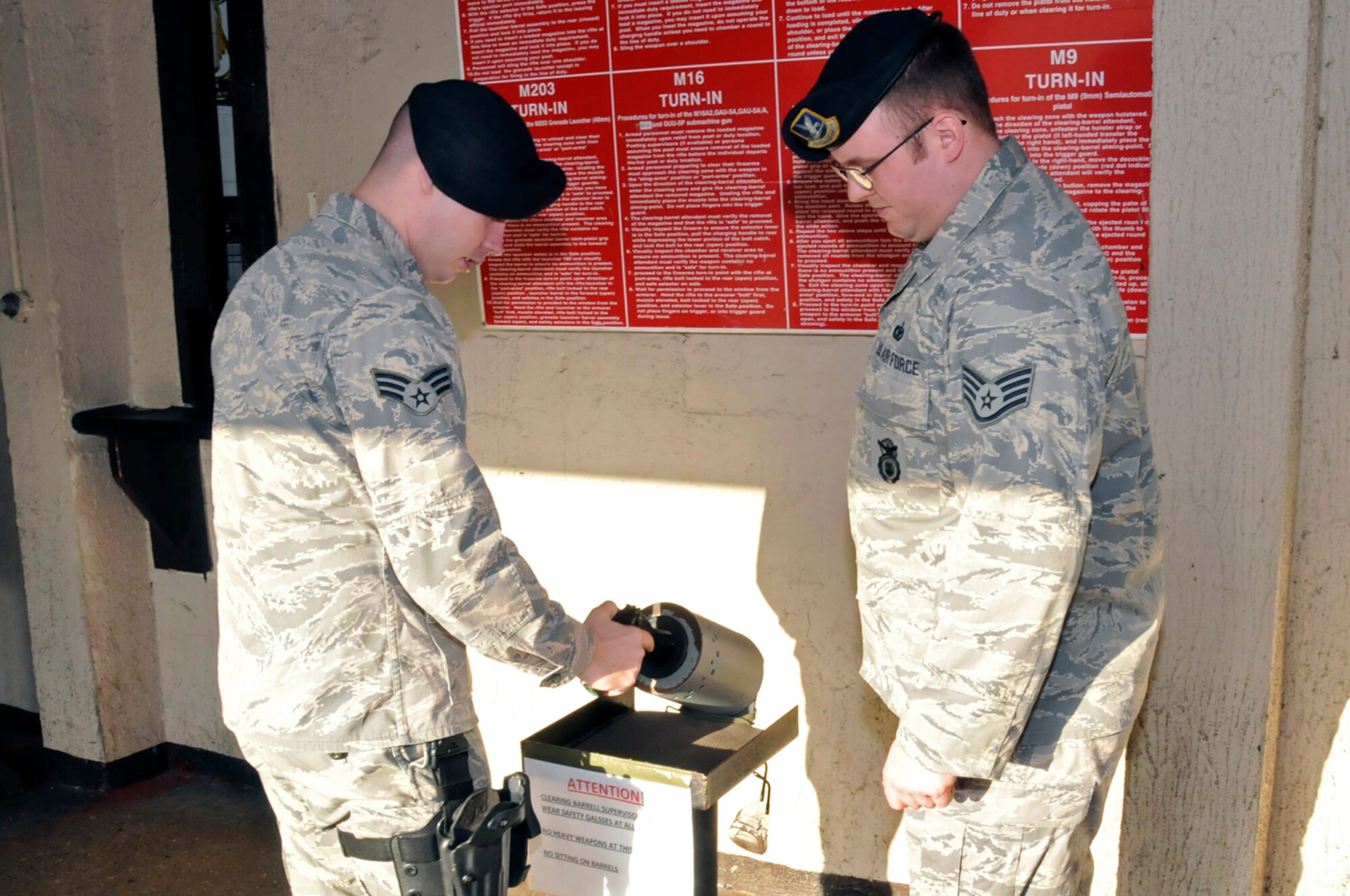 Senior Airman Craig Sams, 48th Security Forces Squadron, clears his M9 Pistol in front of the clearing barrel supervisor, Staff Sgt. Mark Bryan, Jan. 27 at RAF Lakenheath, England. Airman Sams must ensure his weapon is cleared and safed before turning it into the armory. (U.S. Air Force photo by Airman 1st Class Perry Aston) 