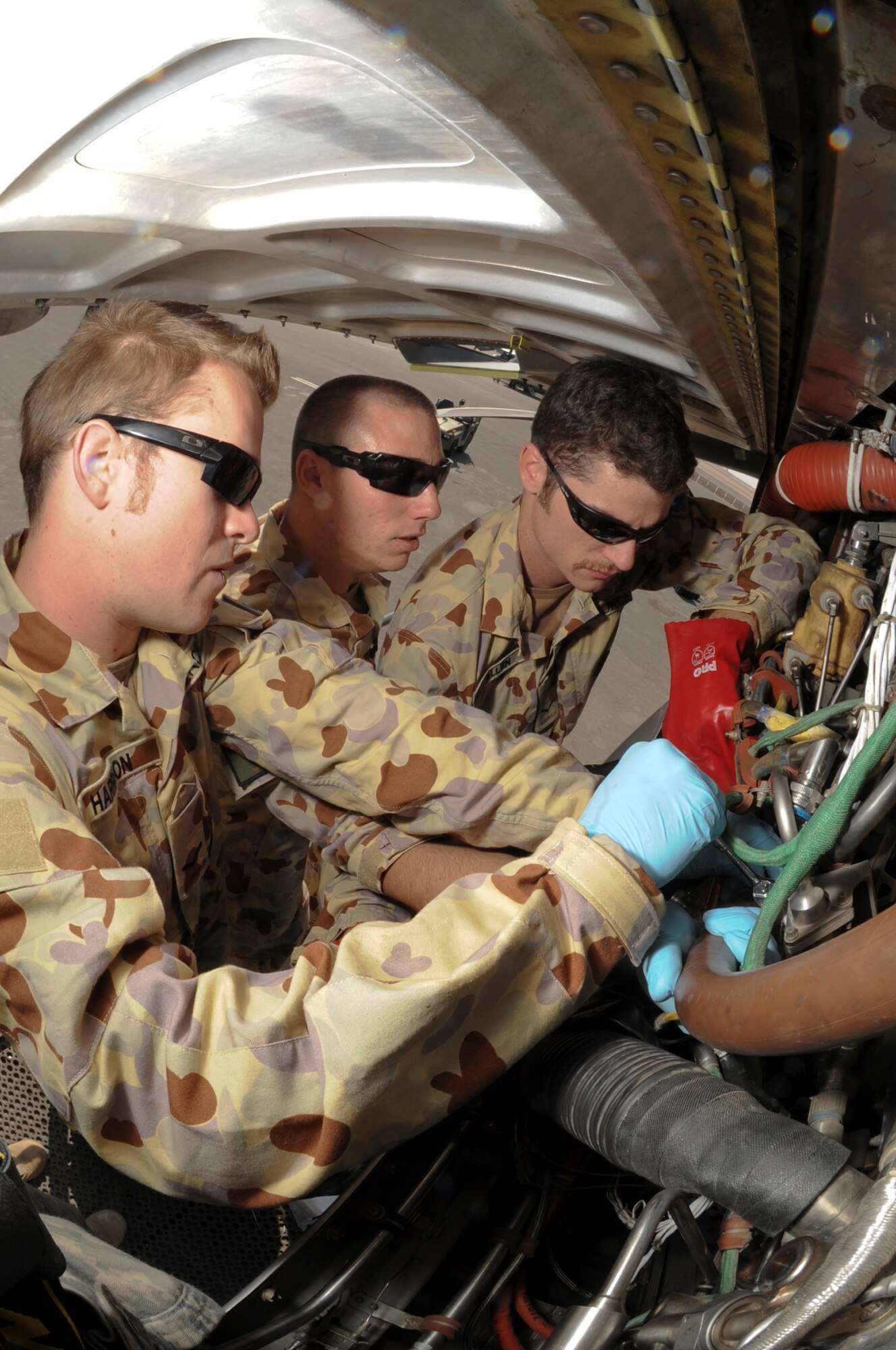 Leading Aircraftman Daniel Harrison, Leading Aircraftman Christopher Line, and Leading Aircraftman Greg Allan, all with the Royal Australian Air Force, prepare to remove a fuel pump metering unit from an engine on a C-130J Hercules, Jan. 28 2009 at an undisclosed location in Southwest Asia.  The metering unit measures the amount of fuel that flows through the engine during flight.  LC Harrison, LC Line, and LC Allan are all deployed in support of Operations Iraqi and Enduring Freedom and Combined Joint Task Force - Horn of Africa. (U.S. Air Force Photos by Staff Sgt. Joshua Garcia/released)