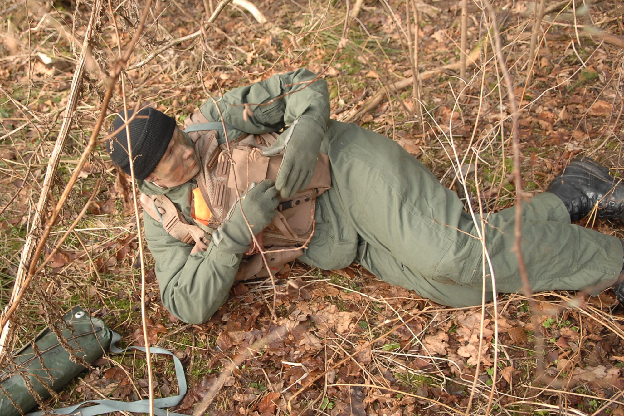 SPANGDAHLEM AIR BASE, Germany – Staff Sgt. Robert A. Martin, 52nd Operations Support Squadron,  reaches into his vest while trying to conceal himself from opposing forces during a Survival Evasion Resistance and Escape training exercise Jan. 27. The purpose of the course was to offer training to evade and escape enemy forces. (U.S. Air Force photo by Airman 1st Class Nicholas Wilson)