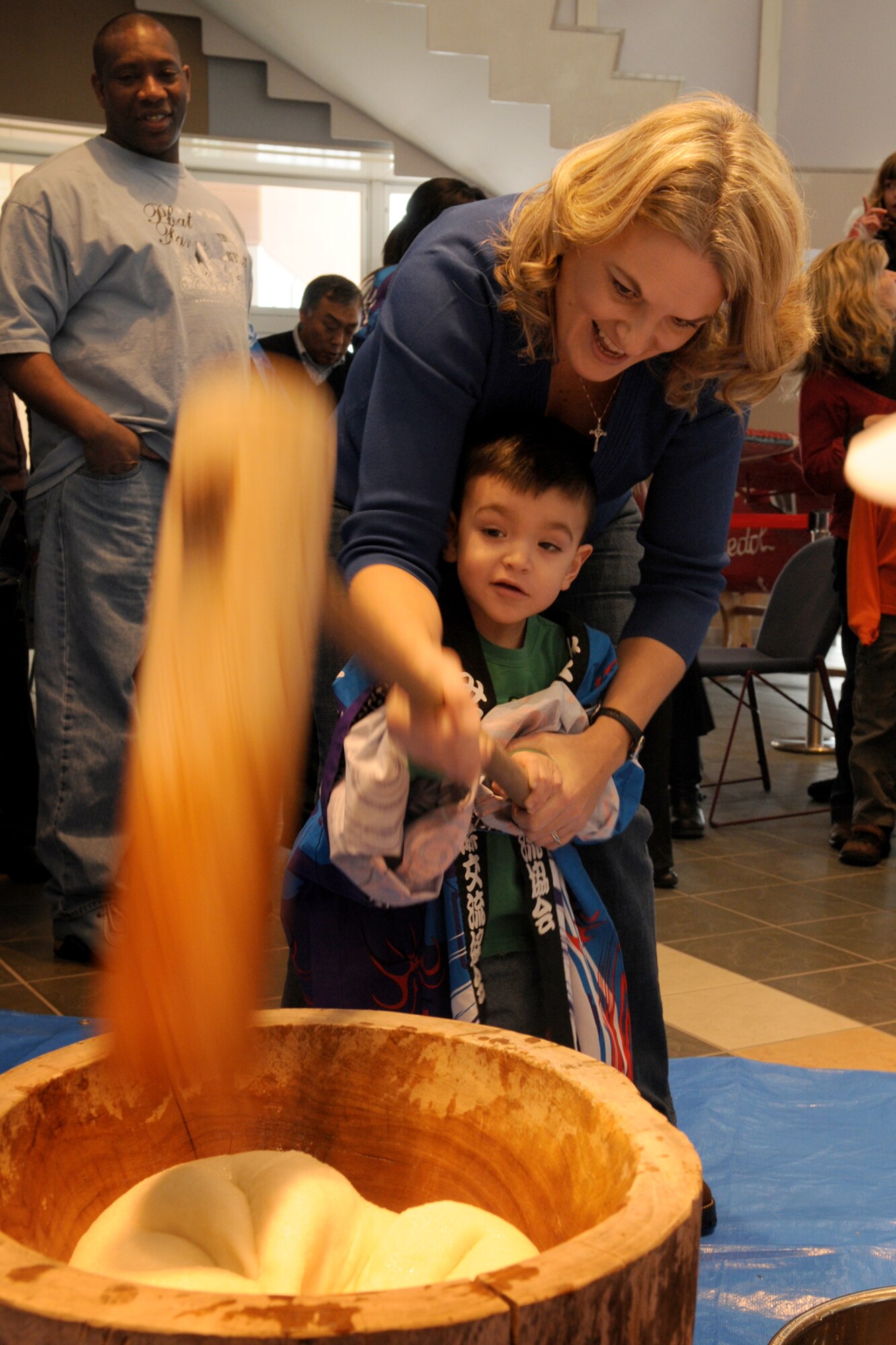 MISAWA CITY, Japan -- Stacy Molinar, wife of Tech. Sgt. Philip Molinar, 301st Intelligence Squadron, and son, Daniel, pound rice during a Shougatsu celebration Jan. 25, 2009, at the Misawa International Center. Once pounded, participants helped mold the paste into "mochi," or rice cake, which is a commonly eaten during the Japanese New Year's celebration. (U.S. Air Force photo by Senior Airman Jamal D. Sutter)