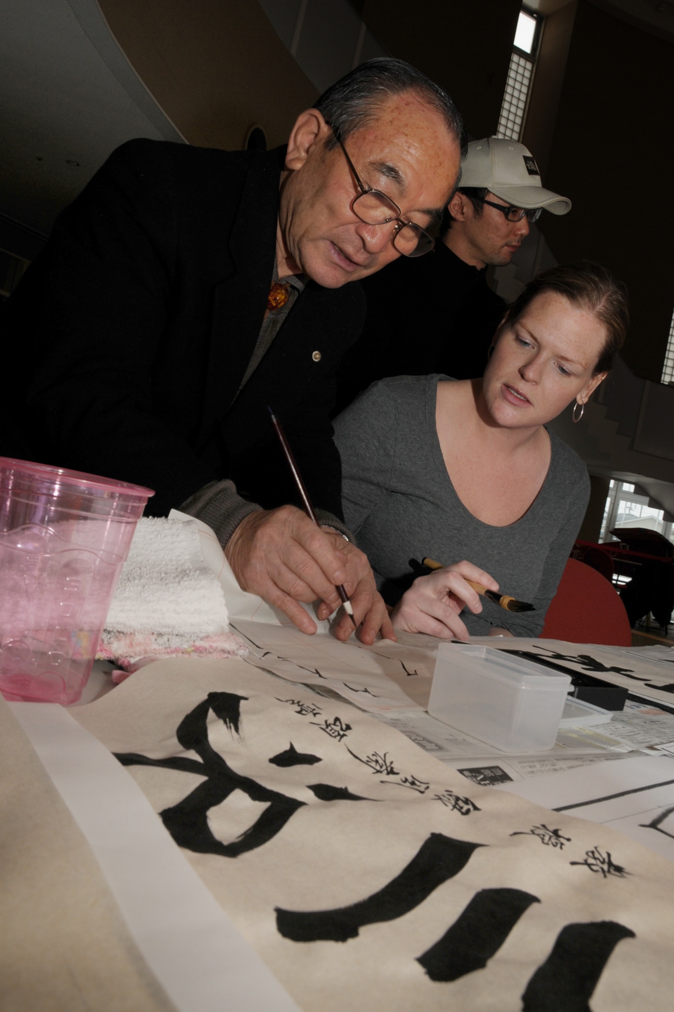 MISAWA CITY, Japan -- Yosuo Minakawa assists Kristy Minnett, 35th Medical Group, with calligraphy during a Shougatsu celebration Jan. 25, 2009, at the Misawa International Center. Shougatsu is a Japanese holiday in which families and friends gather to bring in the new year. (U.S. Air Force photo by Senior Airman Jamal D. Sutter)