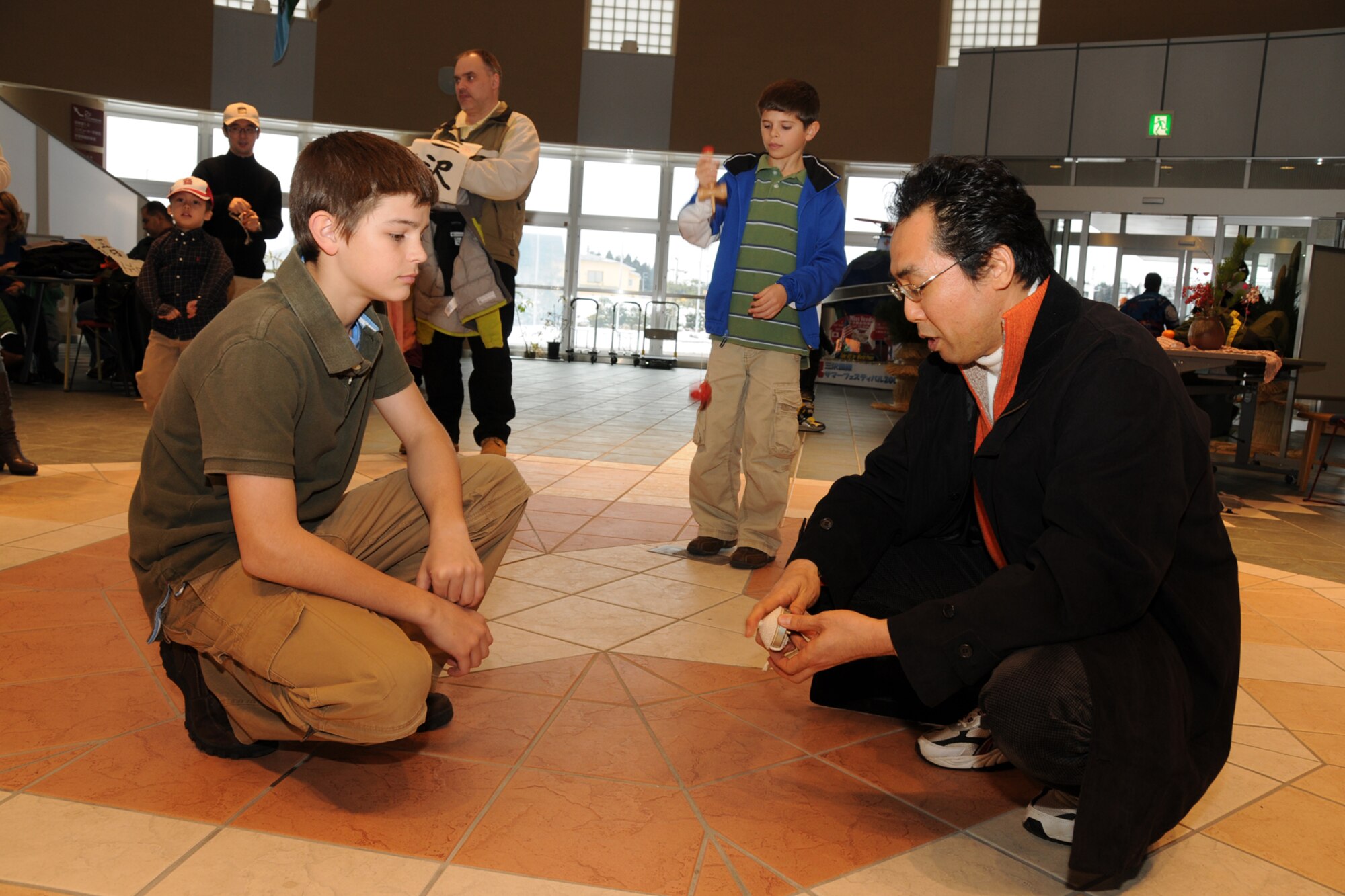 MISAWA CITY, Japan -- Kenji Nakajima teaches Michael Craig, son of Col. RC Craig, 35th Fighter Wing vice commander, how to use a "koma," a spinning top, during a Shougatsu celebration Jan. 26, 2009, at the Misawa International Center. It is customary to play games such as koma during the Japanese New Year's celebration. (U.S. Air Force photo by Senior Airman Jamal D. Sutter)