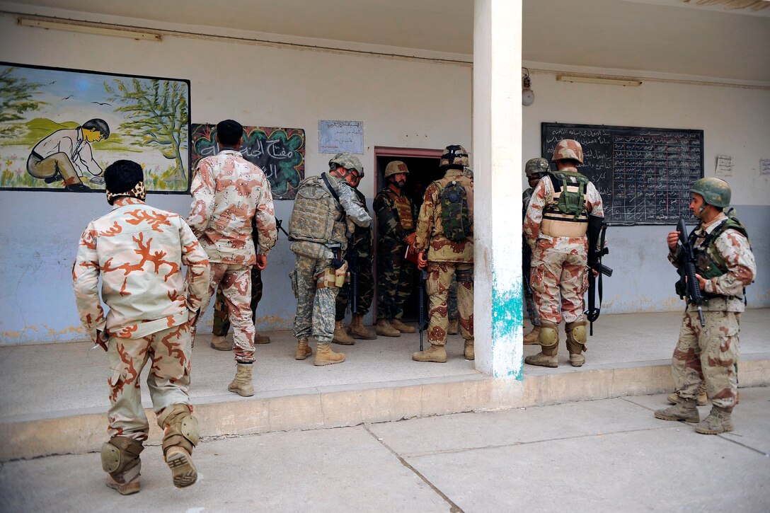 U.S. and Iraqi soldiers visit an election polling station in the Al Karama neighborhood of Mosul, Iraq, Jan. 24, 2009. The soldiers are assigned to the 1st Battalion, 12th Brigade, 3rd Military Transition Team.
