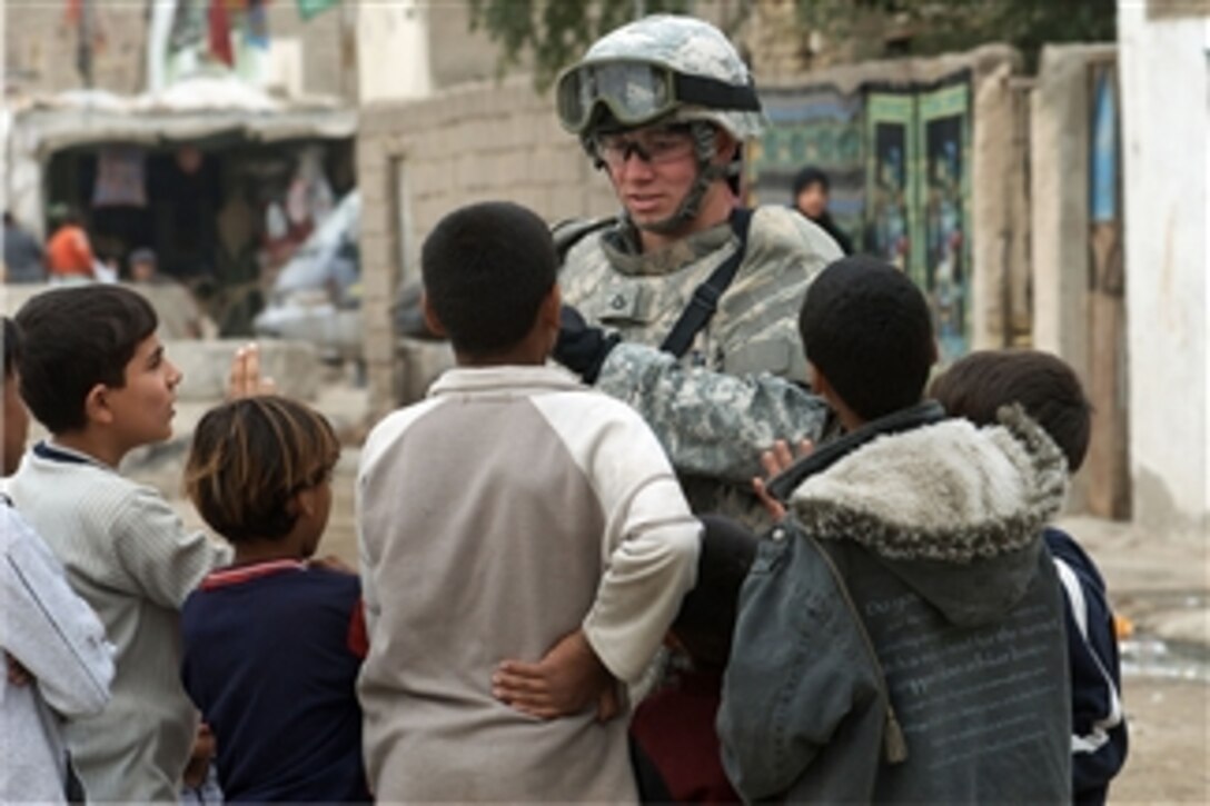 A U.S. Army soldier with the 793rd Military Police Battalion, 8th Military Police Brigade is surrounded by children during the unit's patrol in the Hayyaniyah district of Basra, Iraq, on Jan. 20, 2009.  