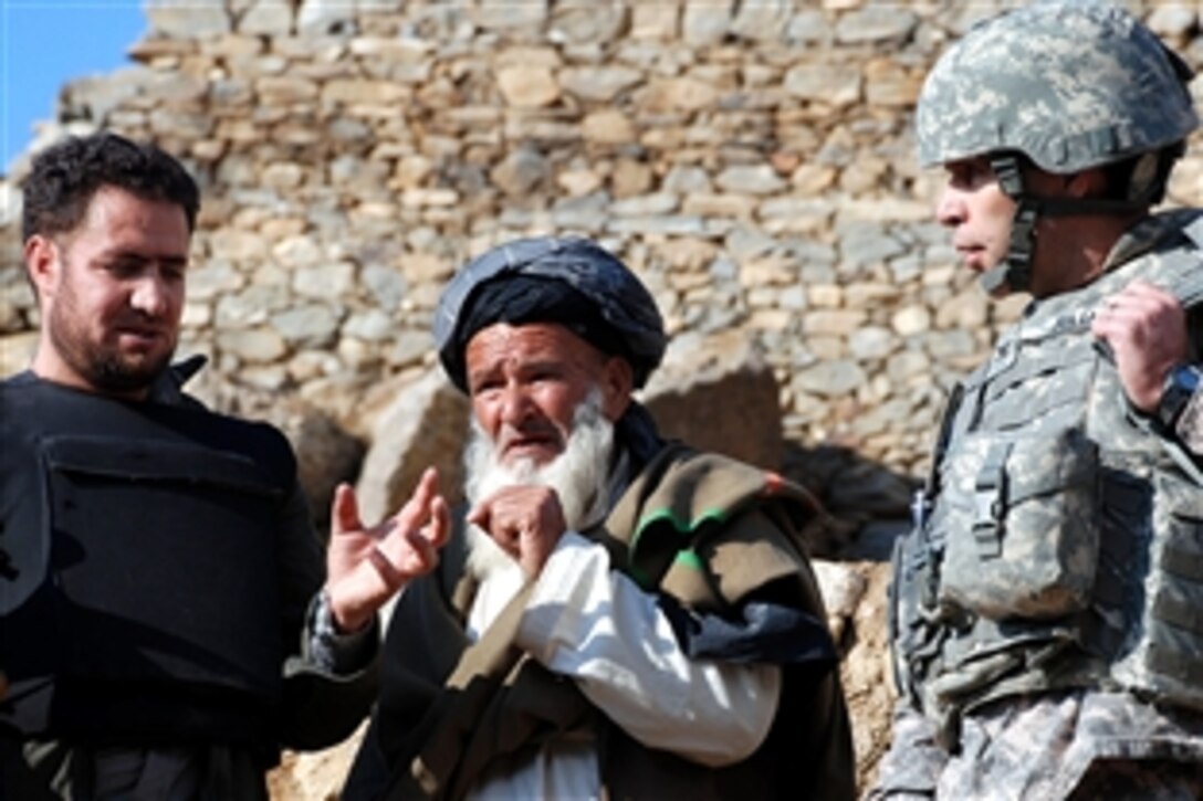 U.S. Army Col. Greg Julian, right, public affairs officer for U.S. Forces Afghanistan, discusses counter-insurgency operations in Tagab, Afghanistan, with a village leader, center, with the help of an interpreter, Jan. 27, 2009. A joint team of Afghan and U.S. officials explored allegations of possible civilian casualties after a recent mission to capture Taliban leaders.