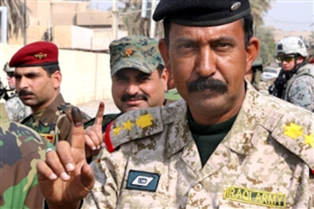 An Iraqi Army colonel raises his right hand outside of the Zafraniyah polling site to show his purple index finger, a sign he voted during the “special” voting day of the provincial elections in Baghdad, Iraq, Jan. 28, 2009. The vote took place before the general provincial election,  scheduled for Jan. 31, to accommodate Iraqi Security Forces, detainees, hospital patients and other special needs cases.