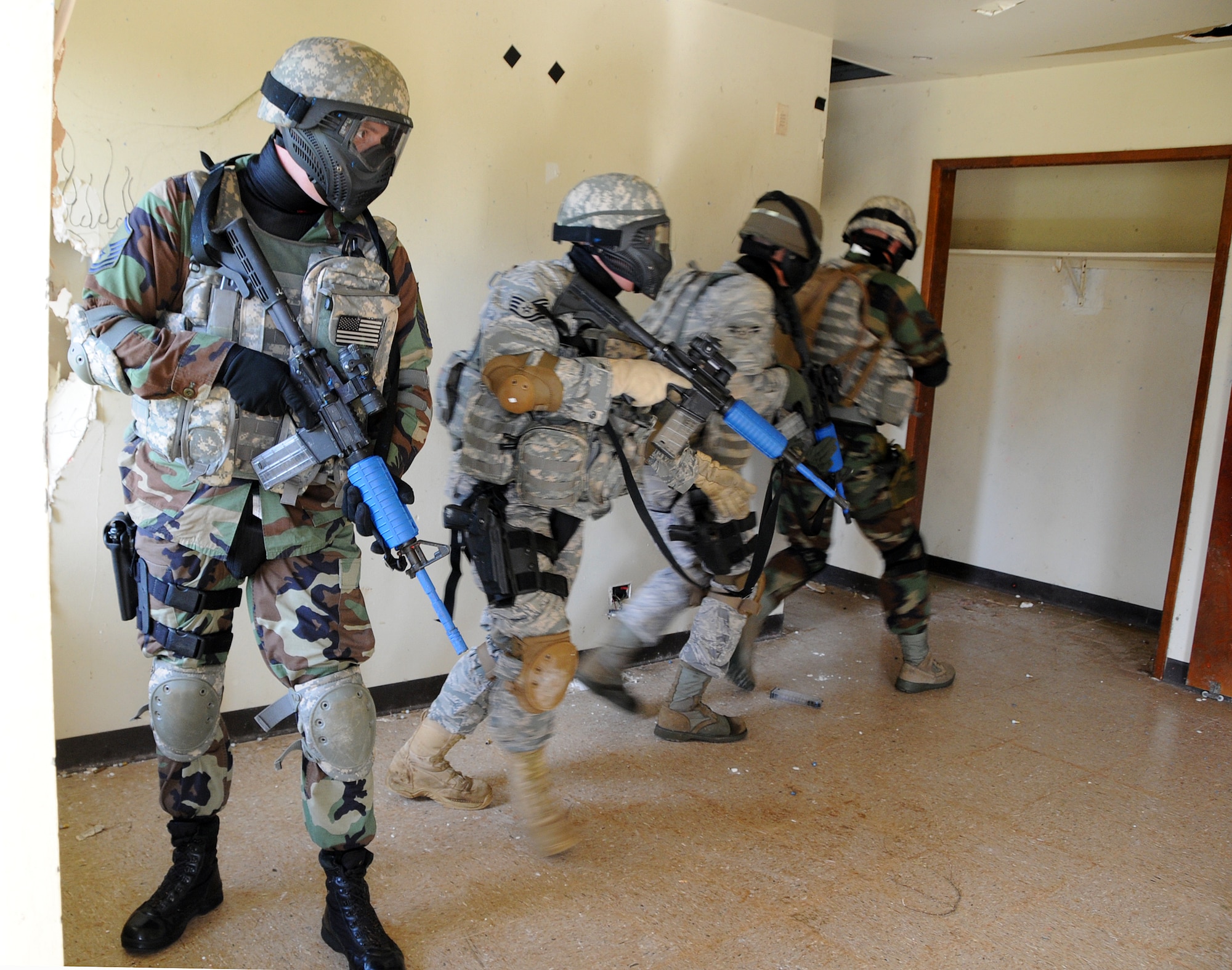 ANDERSEN AIR FORCE BASE, Guam - Master Sgt. Bryan Mooreberg, Squad Leader from Kulis Air National Guard, stands guard as his team checks an abandoned house for potential "enemies" here during Commando Warrior Urban Operations exercise 09-1 Jan 31. The exercise used "simunitions," dye-filled rounds that fit in M4s or 9MM weapons, to train Airmen on team tactics and movement under fire in simulated combat environments. (U.S. Air Force photo by Airman 1st Class Courtney Witt)

