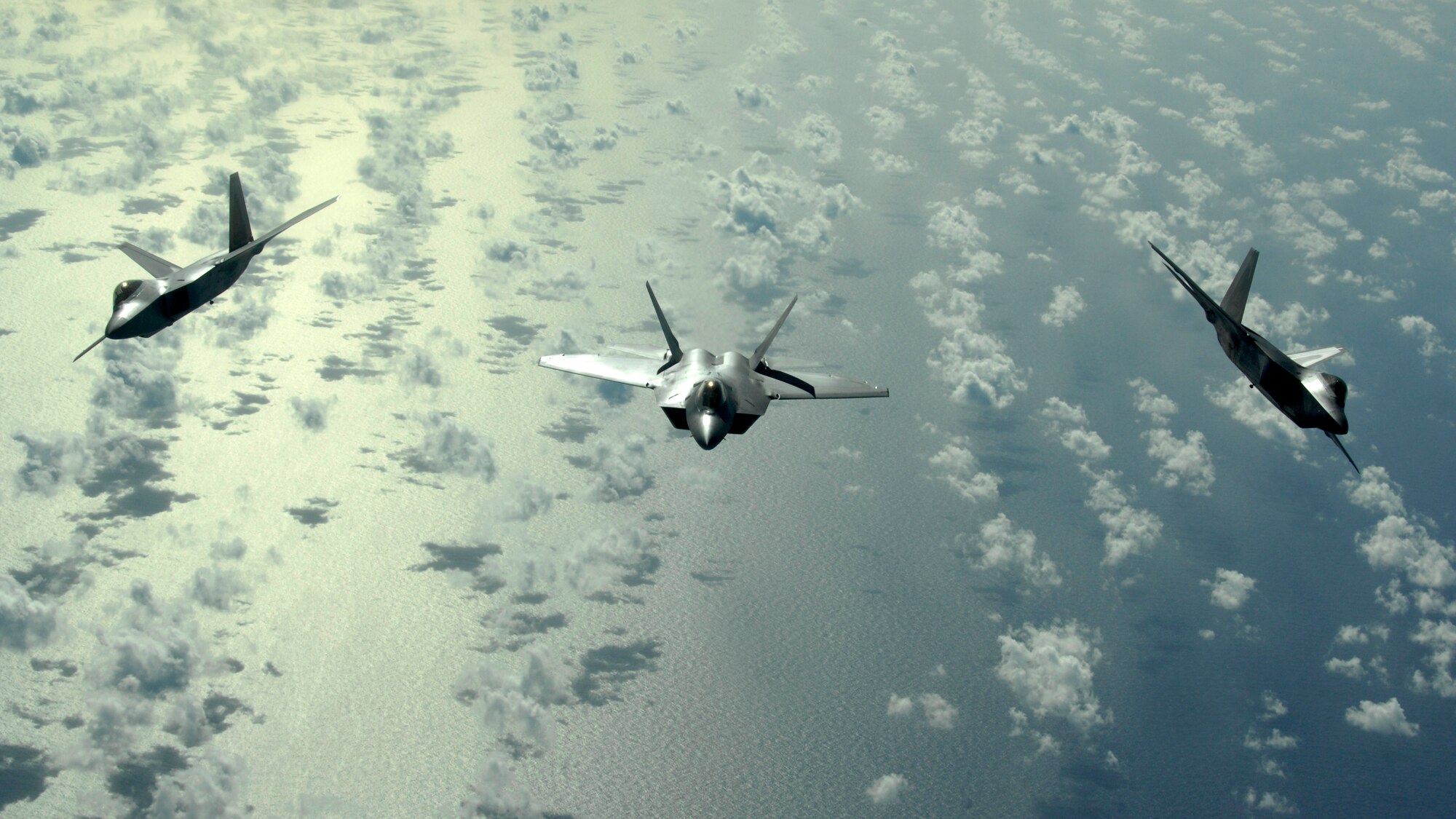 ANDERSEN AIR FORCE BASE, Guam - A three-ship of F-22 Raptors fly over the Pacific Ocean Jan. 28. The Raptors are deployed from Elmendorf AFB, Alaska, to the 90th Expeditionary Fighter Squadron at Andersen AFB, Guam. Andersen received 12 of the $140 million dollar aircraft and more than 250 Airmen have arrived at the base for a three-month deployment as part of the Pacific's Theater Security Package. The stealth-fighters, along with associated maintenance and support personnel will participate in various exercises that provide routine training in an environment different from their home station.  (U.S. Air Force photo Master Sgt. Kevin J. Gruenwald)
