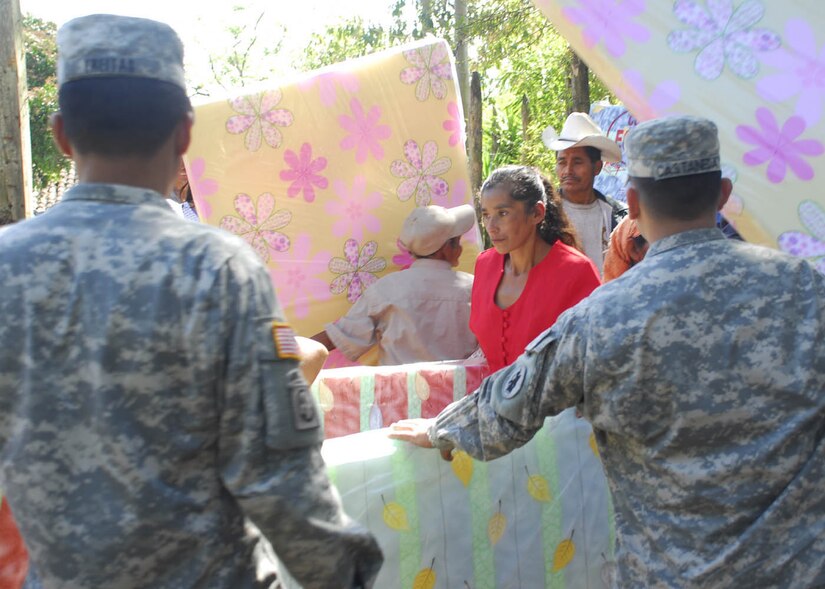 SOTO CANO AIR BASE, Honduras - A woman from El Mangos, Honduras, a remote mountain village near La Paz, receives a mattress being distributed by Joint Task Force-Bravo personnel.  Altogether, the men and women of JTF-B distributed more than 200 mattresses to people in three villages to replace mattresses that were destroyed during recent floods.  (US Air Force photo/Tech Sgt. Rebecca Danét)