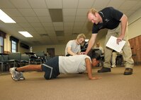 1/21/2009 - Staff Sgt. Tanya Barnes, 37th Comptroller Squadron, and Byron Black help Senior Airman Dominique Campos work on the proper form for push ups at the Health and Wellness Center. Airman Campos is with the 59th Medical Wing. (USAF photo by Robbin Cresswell) 