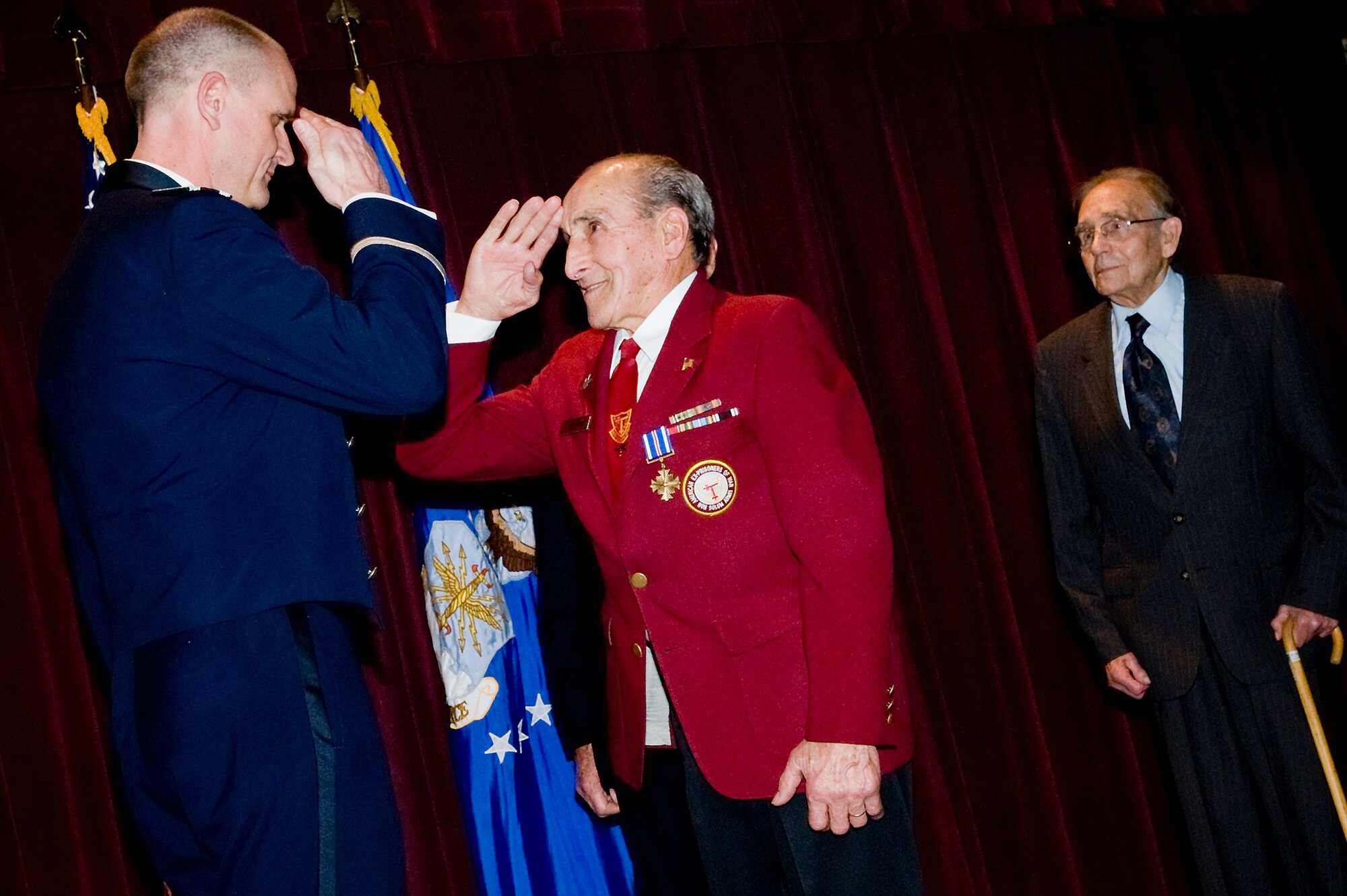 Army Air Corps veteran Joseph Moser, center, salutes Col. Jeffrey Stephenson, 62nd Airlift Wing commander, left, after receiving the Distinguished Flying Cross at McChord's Annual Awards Banquet Jan. 29. (U.S. Air Force photo/Abner Guzman)