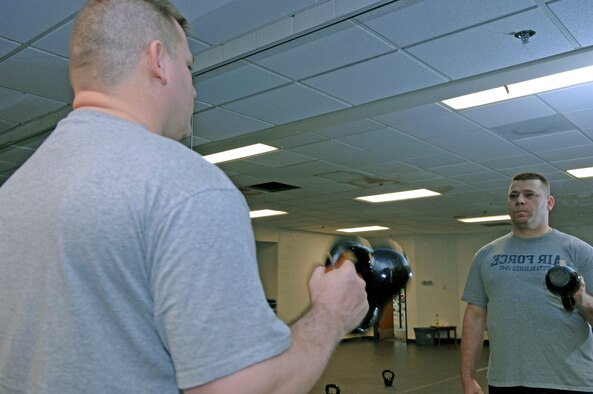 Staff Sgt. Kevin Pike, 28th Bomb Wing chaplain assistant, lifts a barbell during a group workout here, Jan.12.  The group workout followed the initial weigh-ins for the Bellamy Fitness Center's "Biggest Loser" competition. (U.S. Air Force photo/Airman 1st Class Abigail Klein)