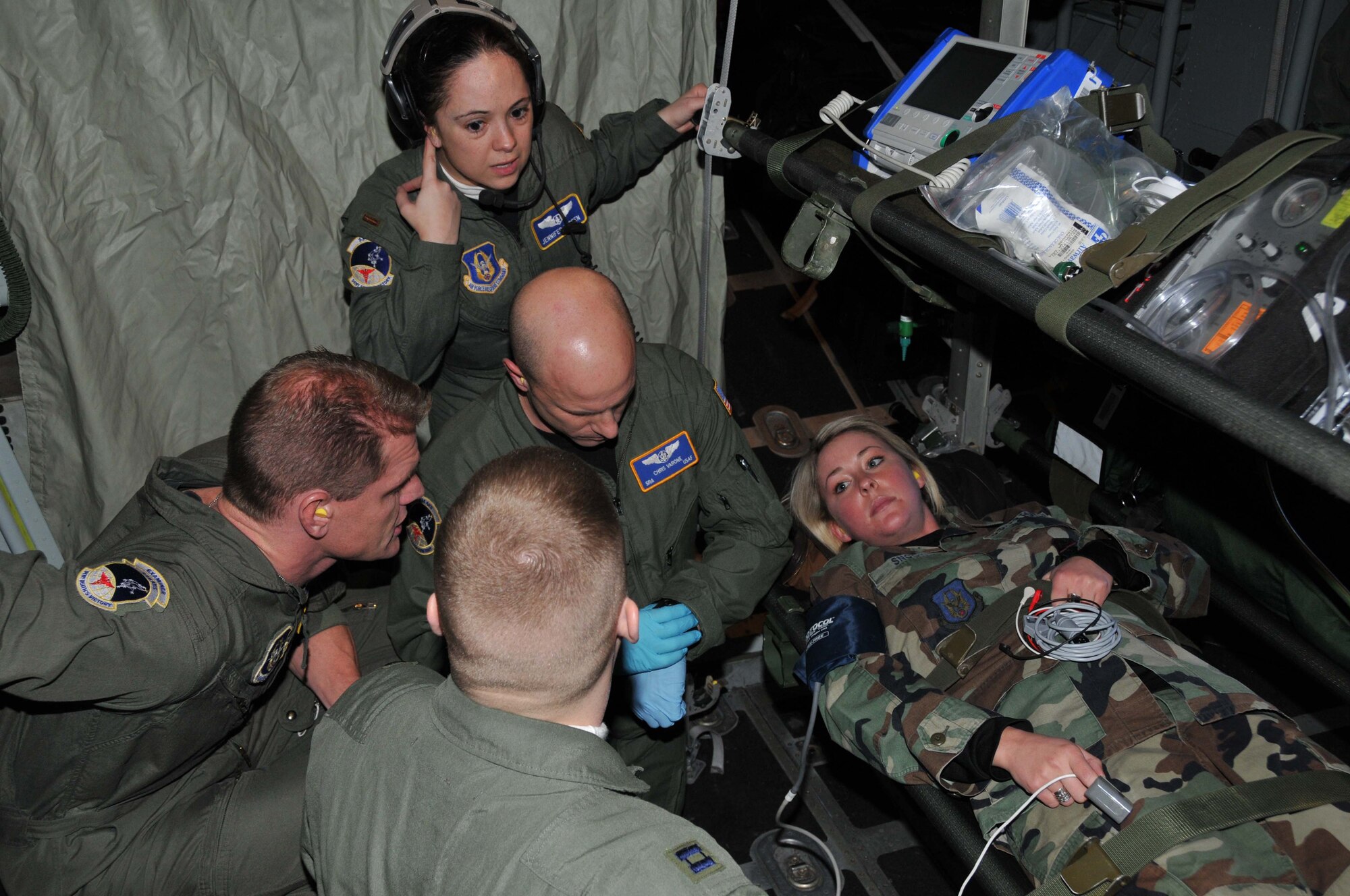 (left to right) ?Patient? Staff Sgt. Rachel Snook is treated by aeromeds Capt. Adam Hohman, Senior Master Sgt. Shane Lohmann, 2nd Lt. Jennifer Larsen and Senior Airman Chris Varone during an in flight training mission. (Air Force Photo/Master Sgt. Darrell Habisch) 

