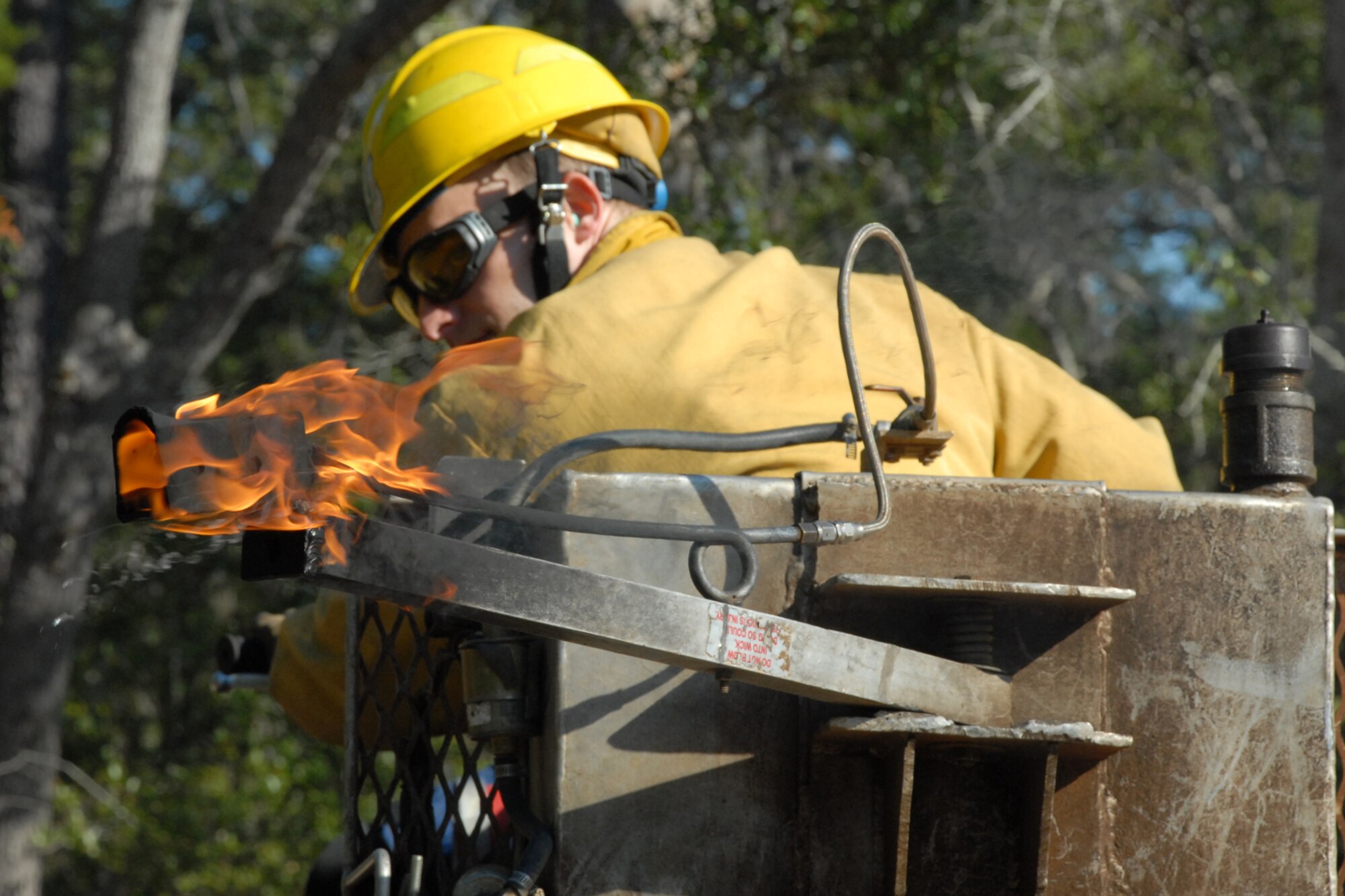 EGLIN AIR FORCE BASE, Fla. -- Tom Murrie, a Jackson Guard forestry technician and wildland fire specialist, uses a mixture of fuels in a drip line to spark a prescribed fire from an all terrain vehicle at White Point, an 85-acre recreation area on the Choctawhatchee Bay Jan. 29. Many native plants and animal species depend on Eglin?s fire-dependent long-leaf pine ecosystem, 11 of which are federally protected. Endangered species such as the red-cockaded woodpecker, depend on fire that is typically caused by either lightning strikes or Eglin's resident fire managers to survive. As of the 2008 control burn season, Jackson Guard's five-year average is 73,000 acres burned annually. (U.S. Air Force Photo by Staff Sgt. Mike Meares)
