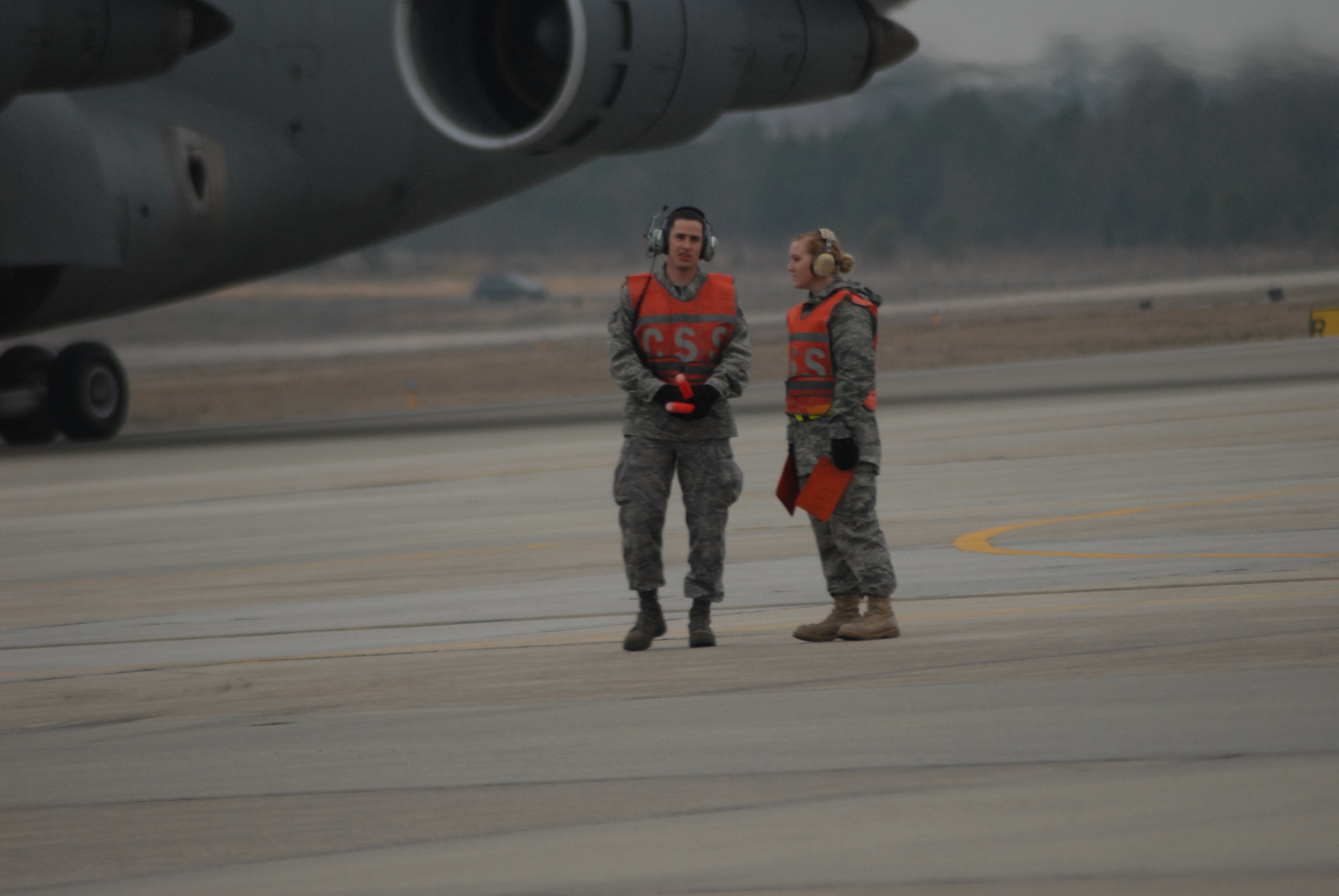 Staff Sgt. Gabriel Stone, 43rd Aircraft Maintenance Squadron, helps Airman Ashley LaGrow, 43rd Comptroller Squadron, marshal in a C-5 aircraft Jan. 27. (U.S. Air Force Photo by Airman 1st Class Mindy Bloem)