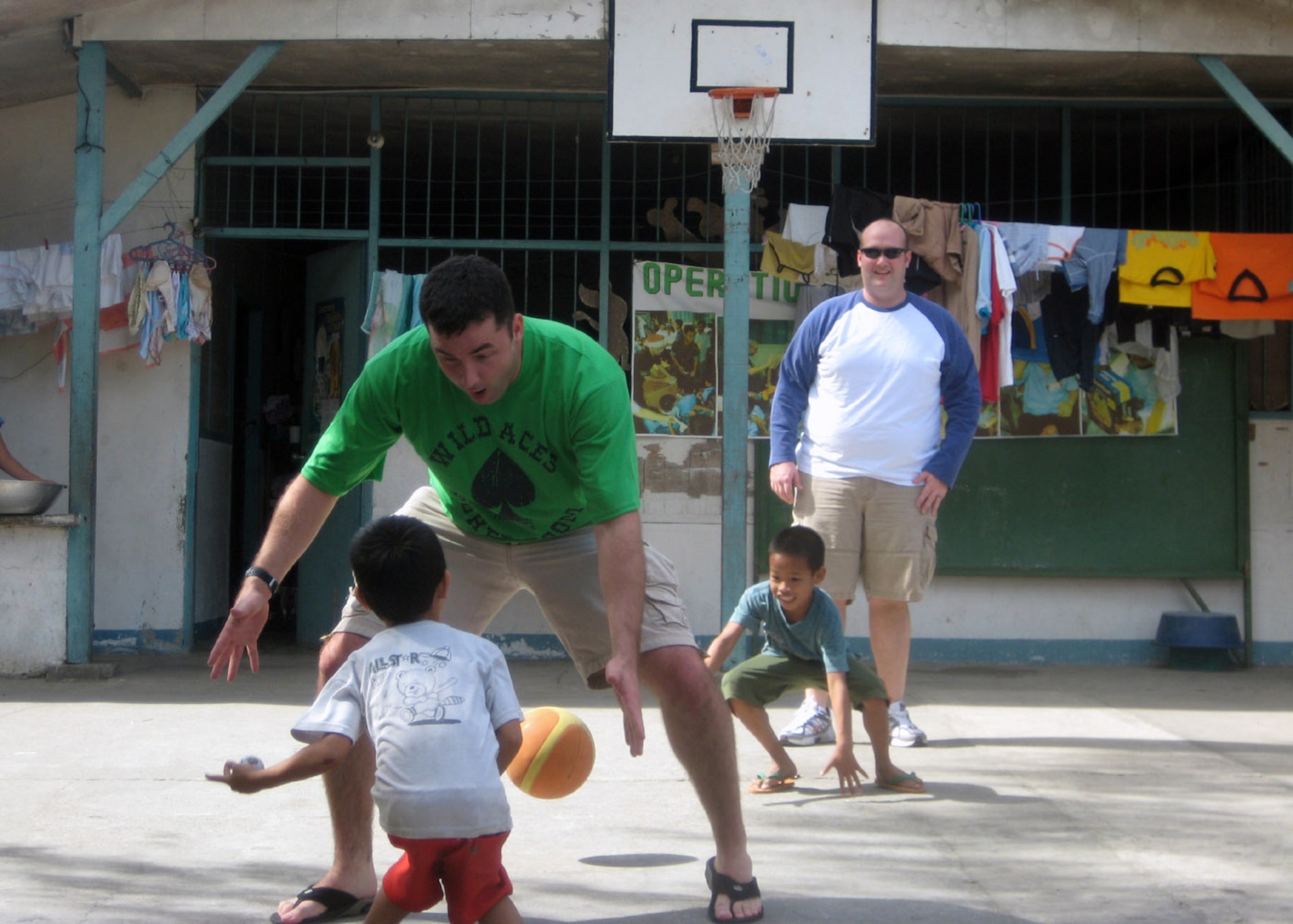 Capt. Zak Blom and Capt. Matt Halladay play basketball with children Jan. 19 at the Duyan ni Maria orphanage in Angeles City, Pampanga in the Philippines. Members of the 17th Special Operations Squadron, 353rd Operations Support Squadron and 25th Intelligence Squadron Det. 3 stopped by the orphanage and single mothers home with boxes of clothing, shoes, toys, books and school supplies. Captain Blom is a 17th SOS pilot, and Captain Halladay is a 17th SOS navigator. (Courtesy photo) 
