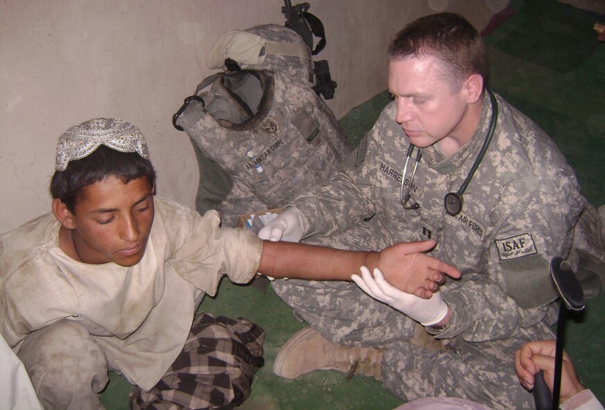 While deployed to Afghanistan, Capt. Timothy Harrelson, family practice physician assistant, 35th Medical Operations Squadron, treats a 14-year-old boy with a dislocated elbow. For Captain Harrelson's efforts during his eight-month deployment, he was awarded the Bronze Star. (Courtesy photo)