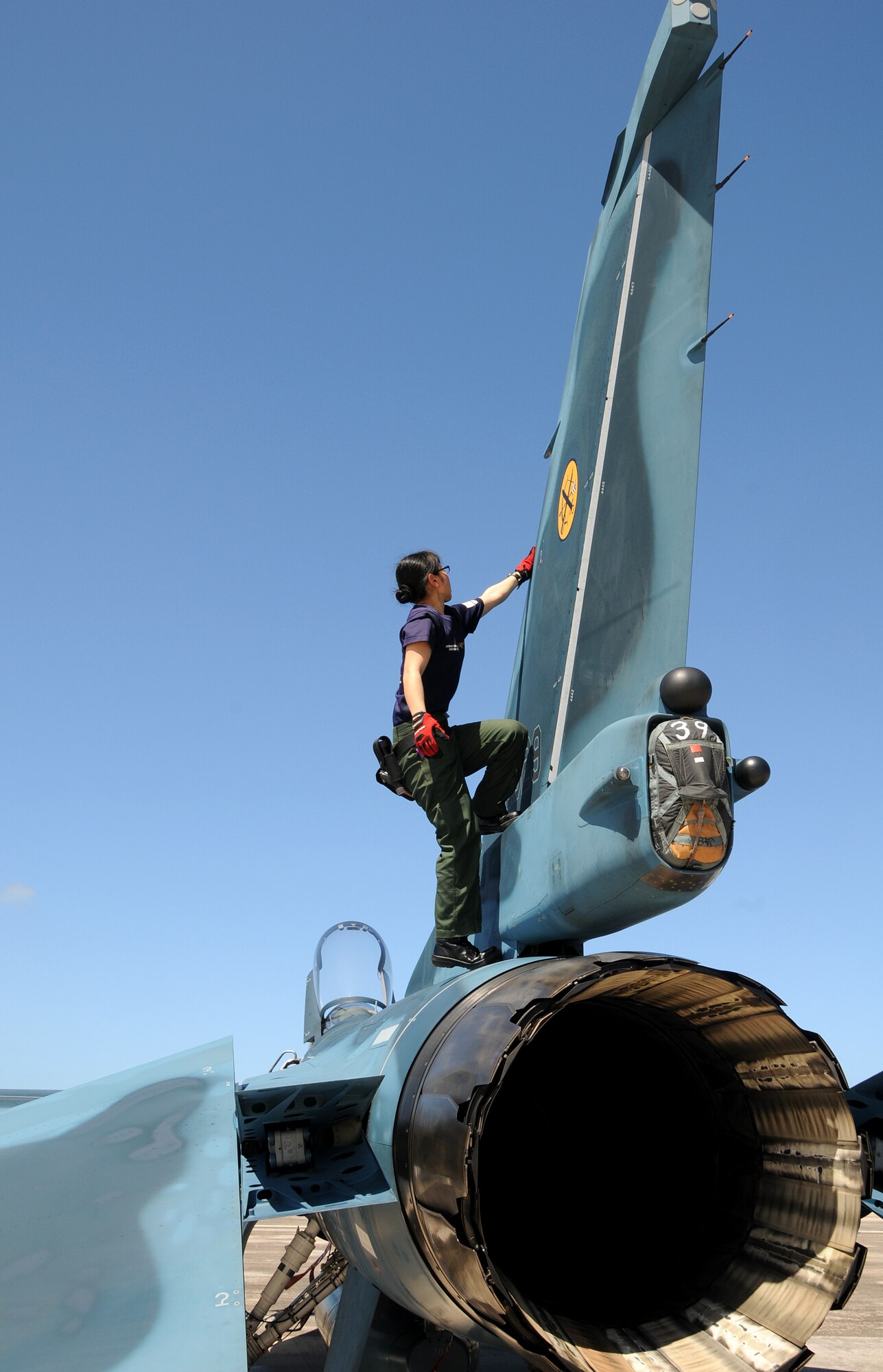 ANDERSEN AIR FORCE BASE, Guam - Japan Air Self Defense Force maintainer Staff Sgt. Teraya Miho inspects the vertical stabilizer of an JASDF F-2 fighter after the aircraft arrived here Jan. 30 for participation in Cope North. This is the tenth time the United States and Japan have held a Cope North exercise on Guam, and it will be the fourth time that the JASDF will use live ordnance. (U.S. Air Force photo by Airman 1st Class Courtney Witt)