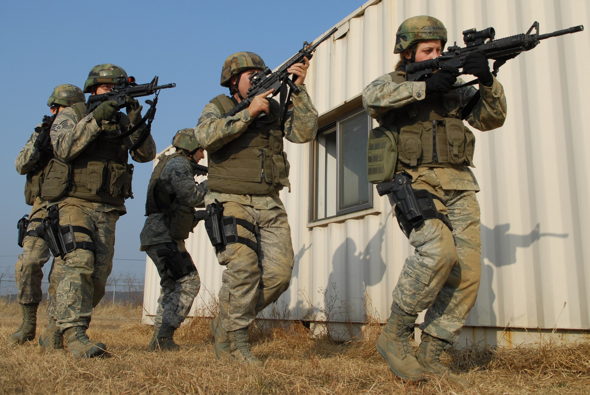 Security Forces Airmen patrol and search the exterior of a building during the 51st Security Forces Squadron combat readiness course Jan. 22 on Osan AB. Newly arriving security forces Airmen go through a six-day combat readiness course designed to prepare SF Airmen by giving them the tools needed to perform the mission. (U.S. Air Force photo/Senior Airman Christopher Boitz)