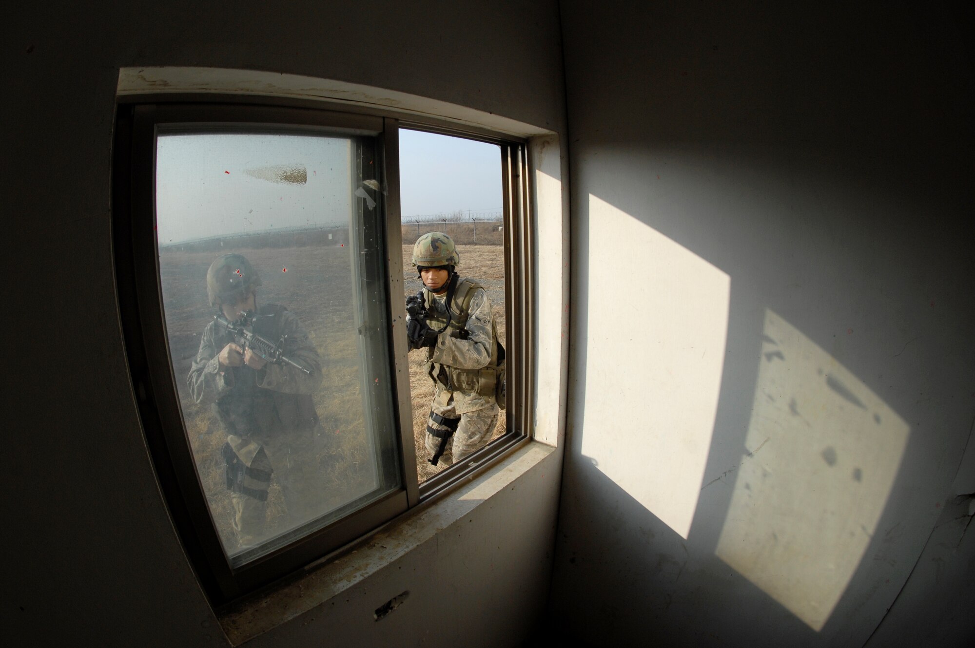 Security Forces Airmen patrol and search the exterior of a building during the 51st Security Forces Squadron combat readiness course Jan. 22 on Osan AB. Newly arriving security forces Airmen go through a six-day combat readiness course designed to prepare SF Airmen by giving them the tools needed to perform the mission. (U.S. Air Force photo/Staff Sgt Brian Ferguson)