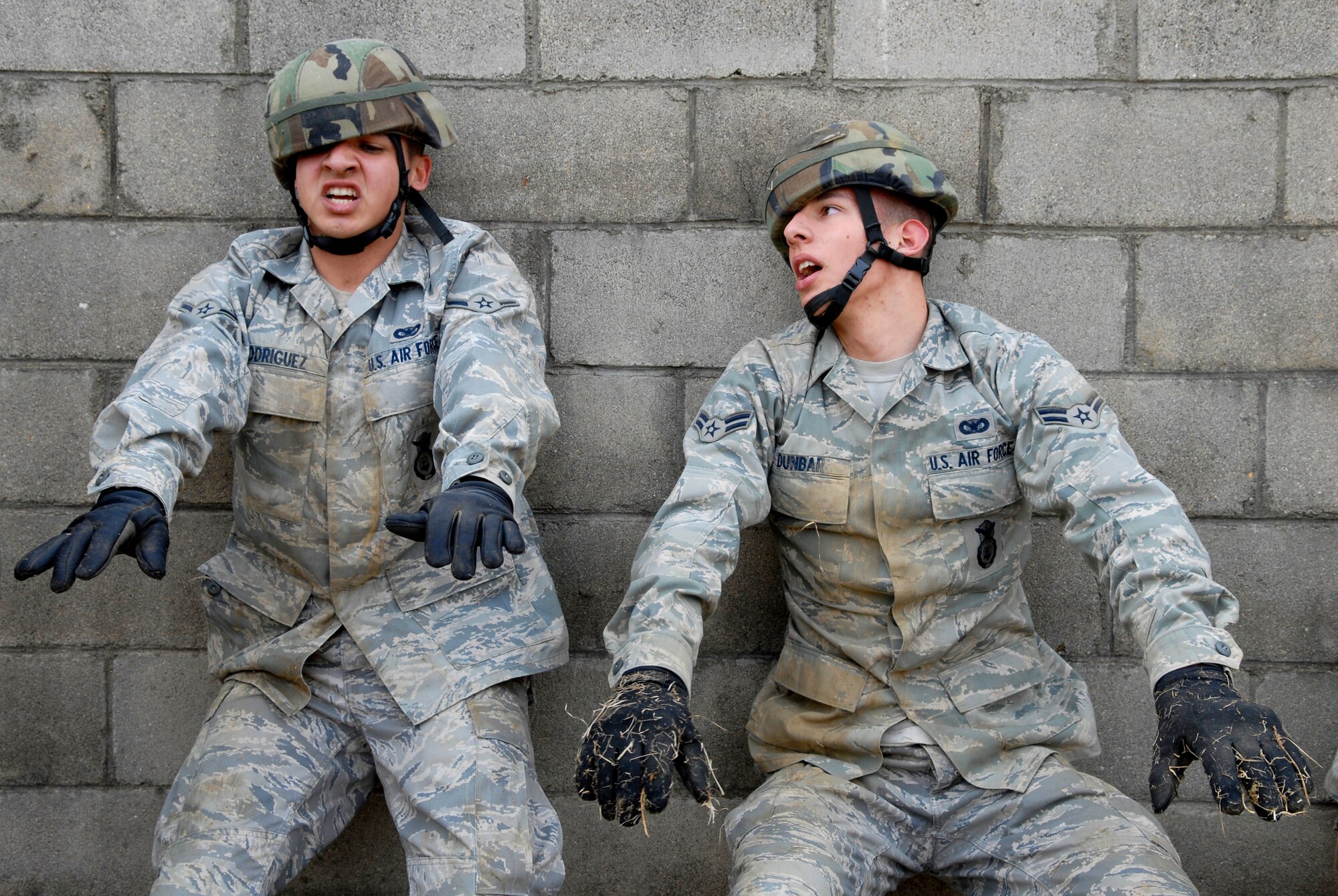 Airman Albert Rodriguez, (Left) and Airman 1st Class Thomas Dunbar perform wall-sits after low-crawling up a hill during the 51st Security Forces Squadron combat readiness course Jan. 22 on Osan AB. Newly arriving security forces Airmen go through a six-day combat readiness course designed to prepare SF Airmen, giving them the tools needed to perform the mission.  Airmen Rodriguez and Dunbar are assigned to the 51st SFS. (U.S. Air Force photo/Staff Sgt Brian Ferguson)