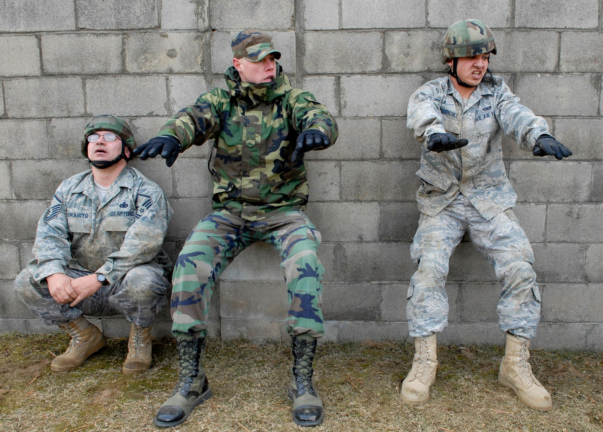 Airman 1st Class Travis Meason, (center) does wall sits with Master Sgt. Anthony Morabito and Airman Albert Rodriguez after low crawling up a hill during a combat readiness course Jan. 22 on Osan AB.  Newly arriving security forces Airmen go through a six-day combat readiness course designed to prepare SF Airmen, giving them the tools needed to perform the mission. Sergeant Morabito, Airman Rodriguez and Meason are all assigned to the 51st SFS. (U.S. Air Force photo/Staff Sgt Brian Ferguson)