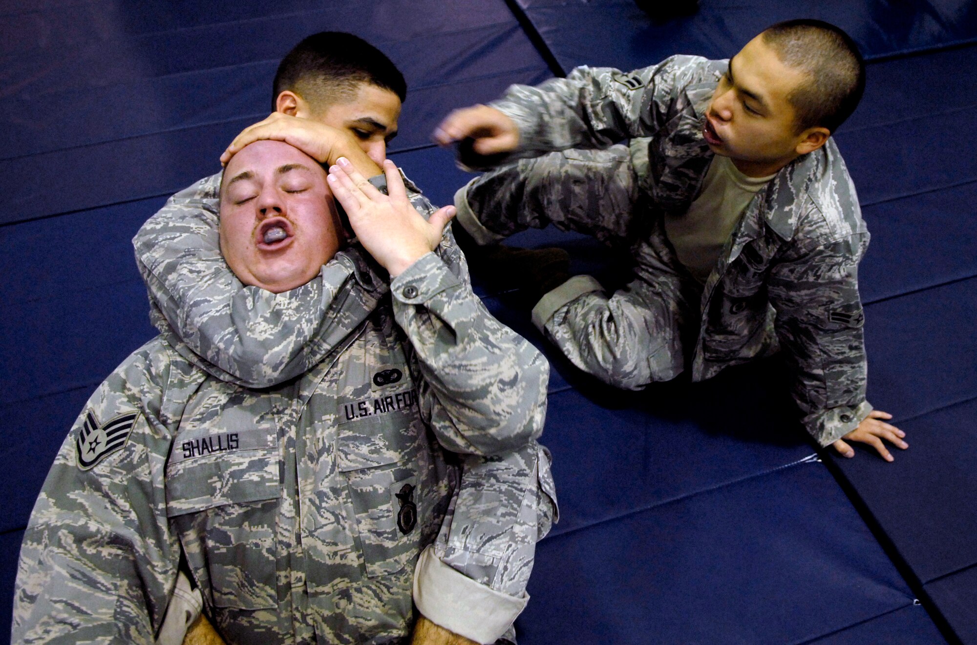 Airman Basic Albert Rodriguez practices the rear-naked-choke on Staff Sgt. George Shallis as Airman 1st Class Her Yang helps with hand placement Jan. 21 at Osan AB.  This combatives class is part of the 51st Security Forces Squadron's combat readiness course designed to prepare SF Airmen by giving them the tools needed to perform the mission. Sergeant Shalls and Airmen Rodriguez and Yang are all assigned to the 51 SFS. (U.S. Air Force photo/Staff Sgt Brian Ferguson)