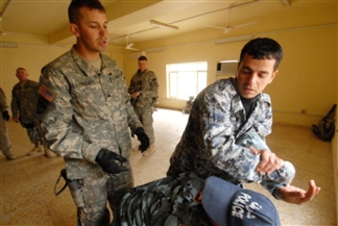 U.S. Army Sgt. James Andrews observes an Iraqi police officer as he practices a restraining technique on a fellow officer during arrest and detainment training at an Iraqi Highway Patrol station along Main Supply Route Tampa in Iraq on Jan. 25, 2009.  Andrews is from 3rd Platoon, 230th Military Police Company, 793rd Military Police Battalion, 18th Military Police Brigade Combat Team.  