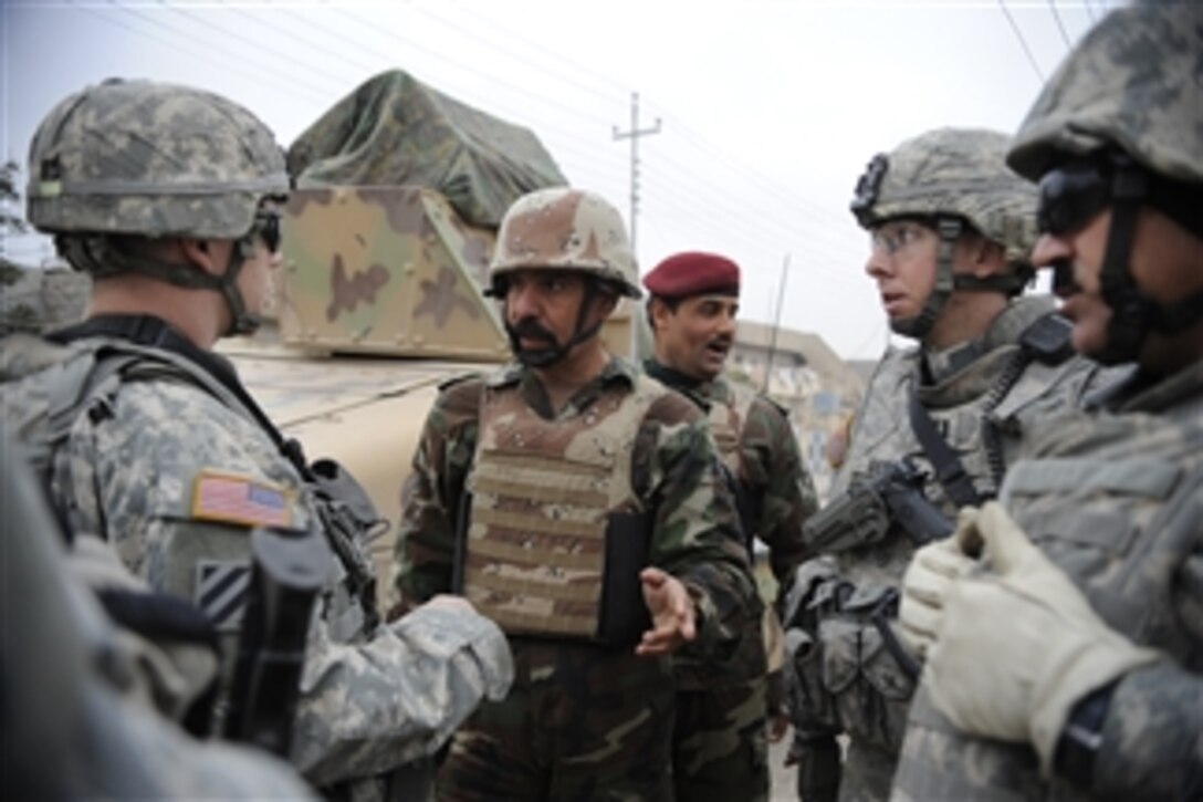 Iraqi Army Maj. Mohammed, executive officer for 3rd Battalion, 9th Brigade, 3rd Division and U.S. Army Capt. David Myers and Capt. Alejandro Gentry, 1st Battalion, 12th Brigade, 3rd Military Transition Team discuss plans for the upcoming elections during a visit to a polling station in the Al Kudis neighborhood of Mosul, Iraq, on Jan. 24, 2009.  