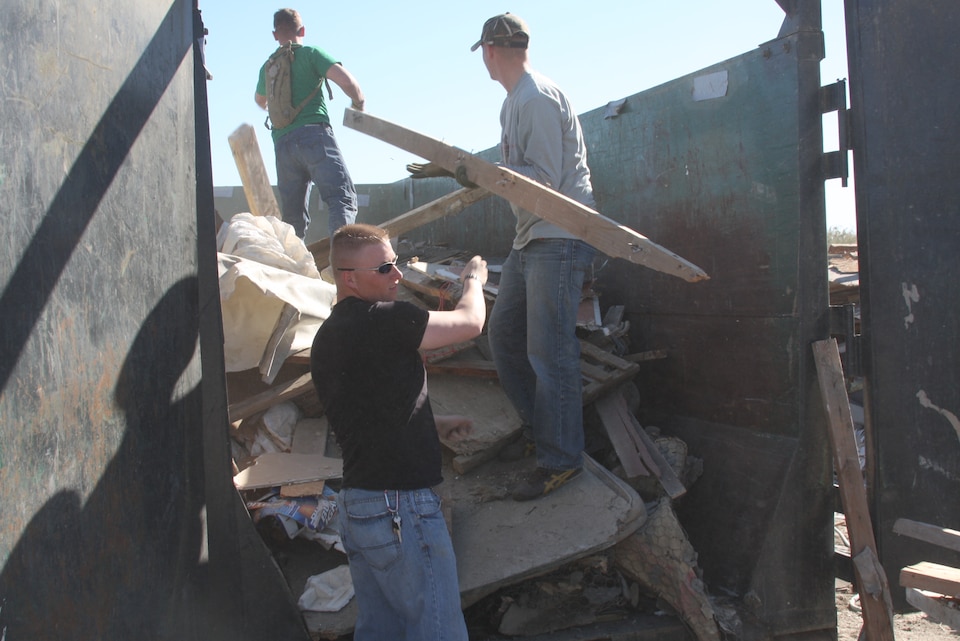 Marines work alongside civilian volunteers during a community outreach program at Duroville, Calif., hosted by the Southwest Community Church in Indian Wells, Calif., Jan. 31.  The Marines had to clear away debris created by the residents of Duroville when they were ordered to remove additions to their trailer homes that once served as spare bedrooms, car ports and porches, due to the fire hazards the construction caused.