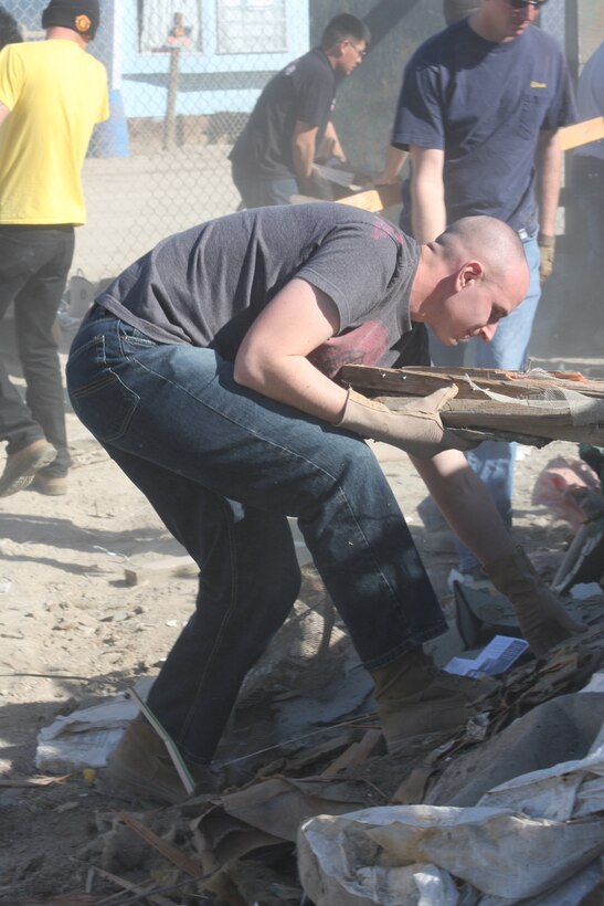 Lance Cpl. David Kedron, a rifleman with Company K, sorts through debris he could carry to the dumpster during a community outreach program the company participated in Jan. 31 in Duroville, Calif.