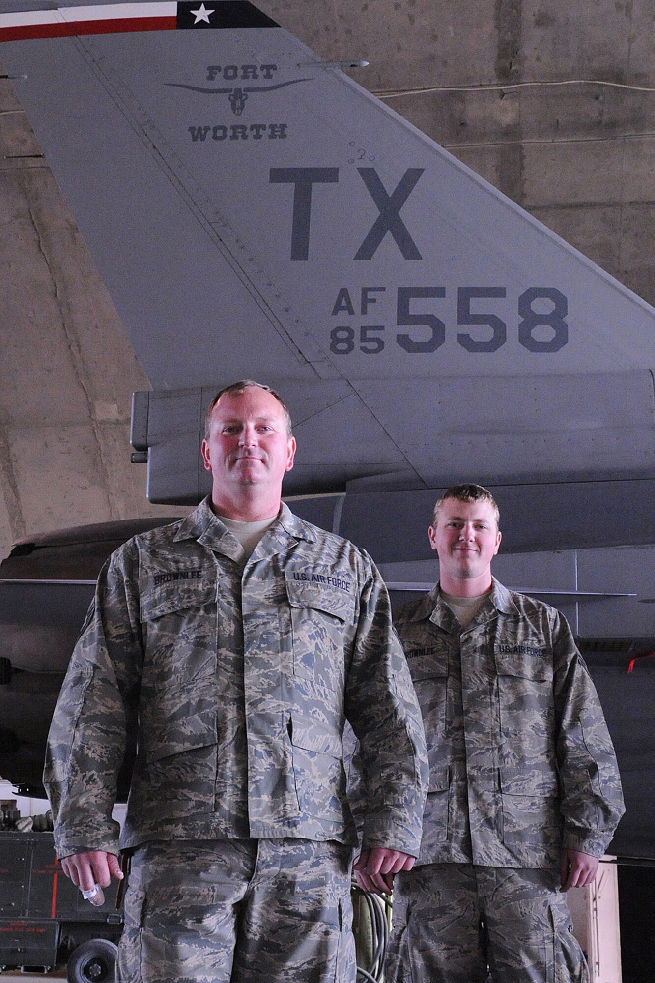 JOINT BASE BALAD, Iraq -- Air Force Reservists Master Sgt. Darrel Brownlee and his son, Senior Airman Kevin Brownlee, 332nd Aircraft Maintenance Squadron aircraft crew chiefs, stand together in front of an F-16 Falcon, here, Jan. 26. The father and son team are deployed from Fort Worth, Texas. (U.S. Air Force photo/Senior Airman Tiffany Trojca)
